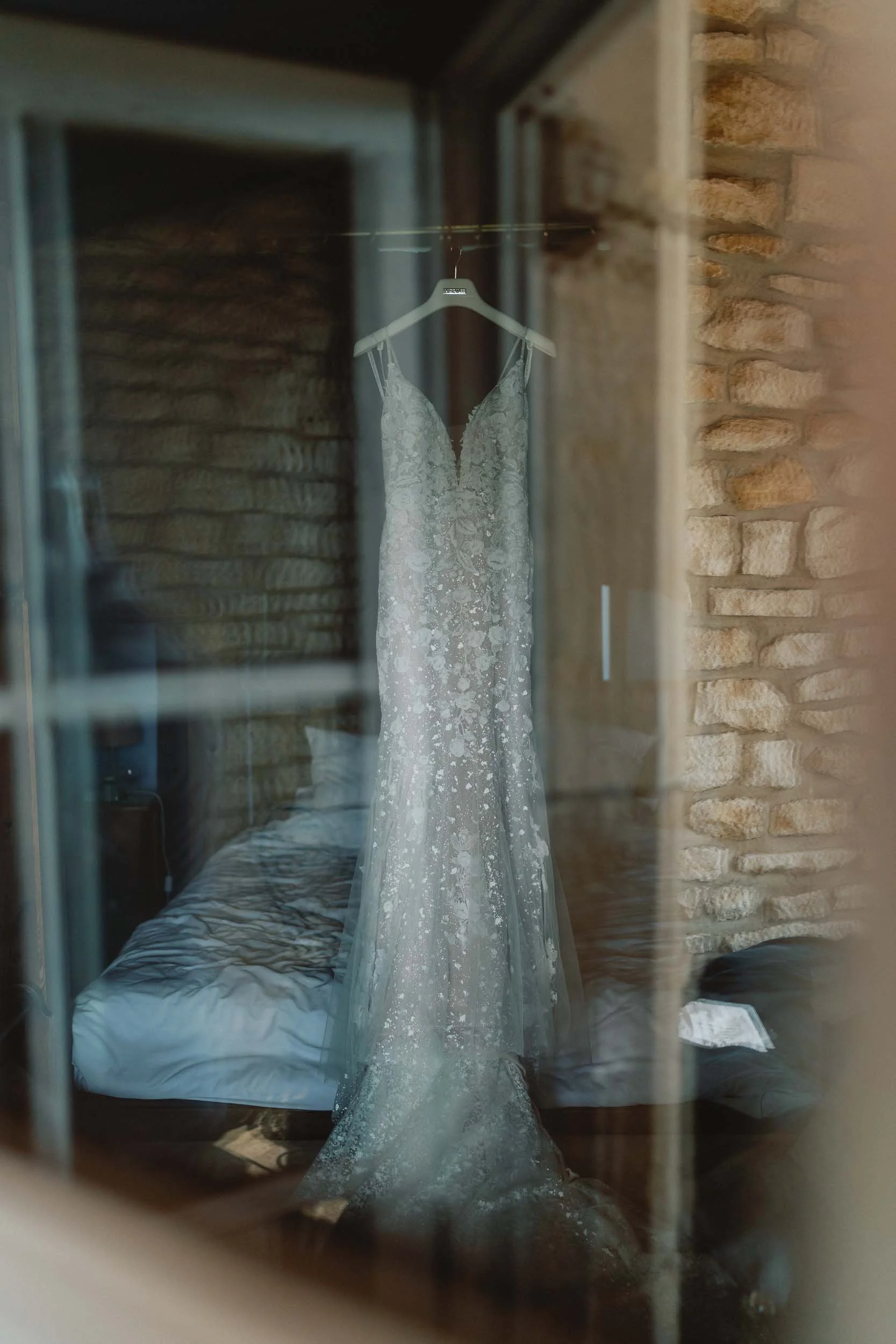 Wedding dress hanging in a window at Château du Raysse, Dordogne