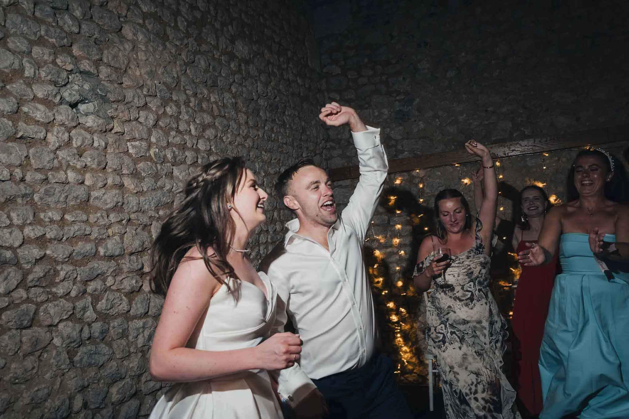 Bride and groom dancing enthusiastically during the party.