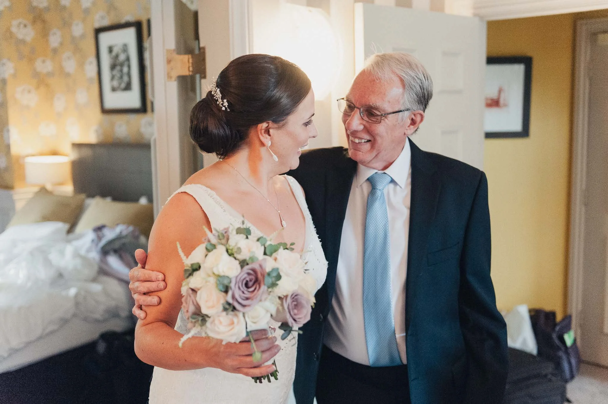 Bride sharing a warm moment with a family member before leaving for the ceremony.