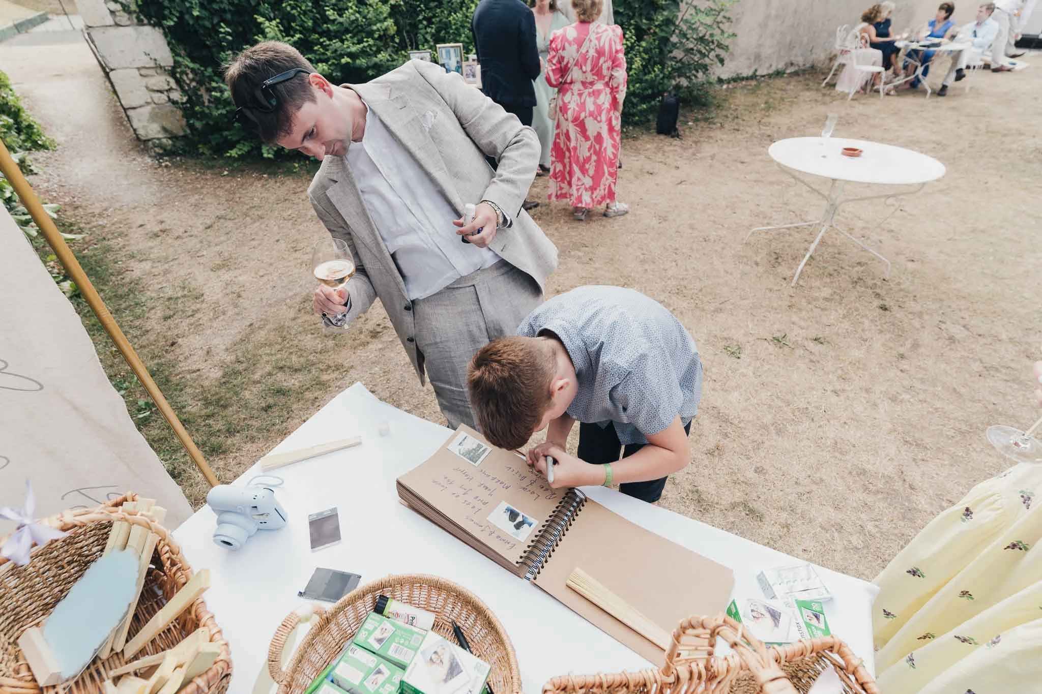 Young guest writing in the wedding guestbook during the afternoon reception.
