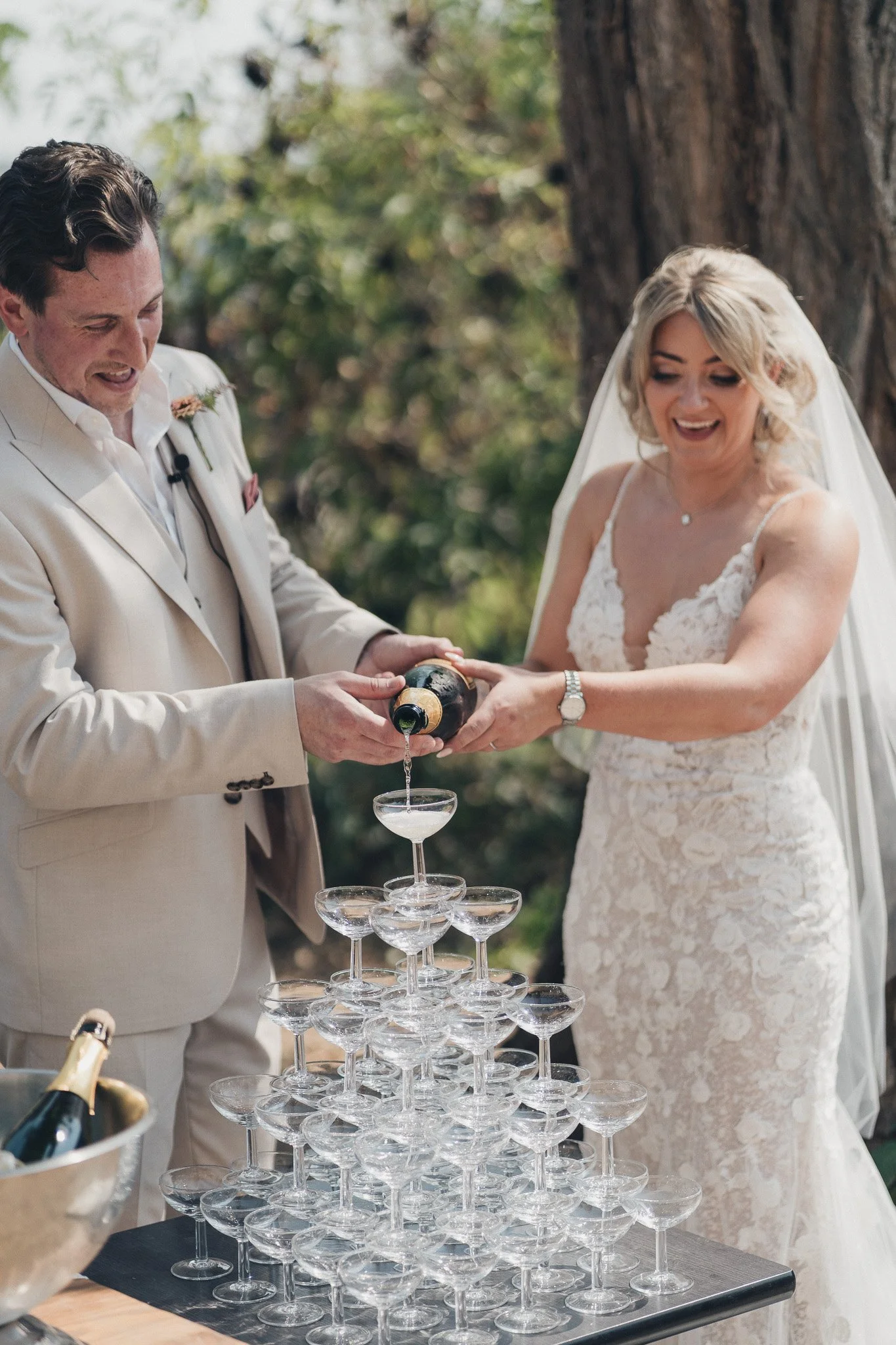 Couple pouring champagne into a tower during their wedding reception in southwest France.