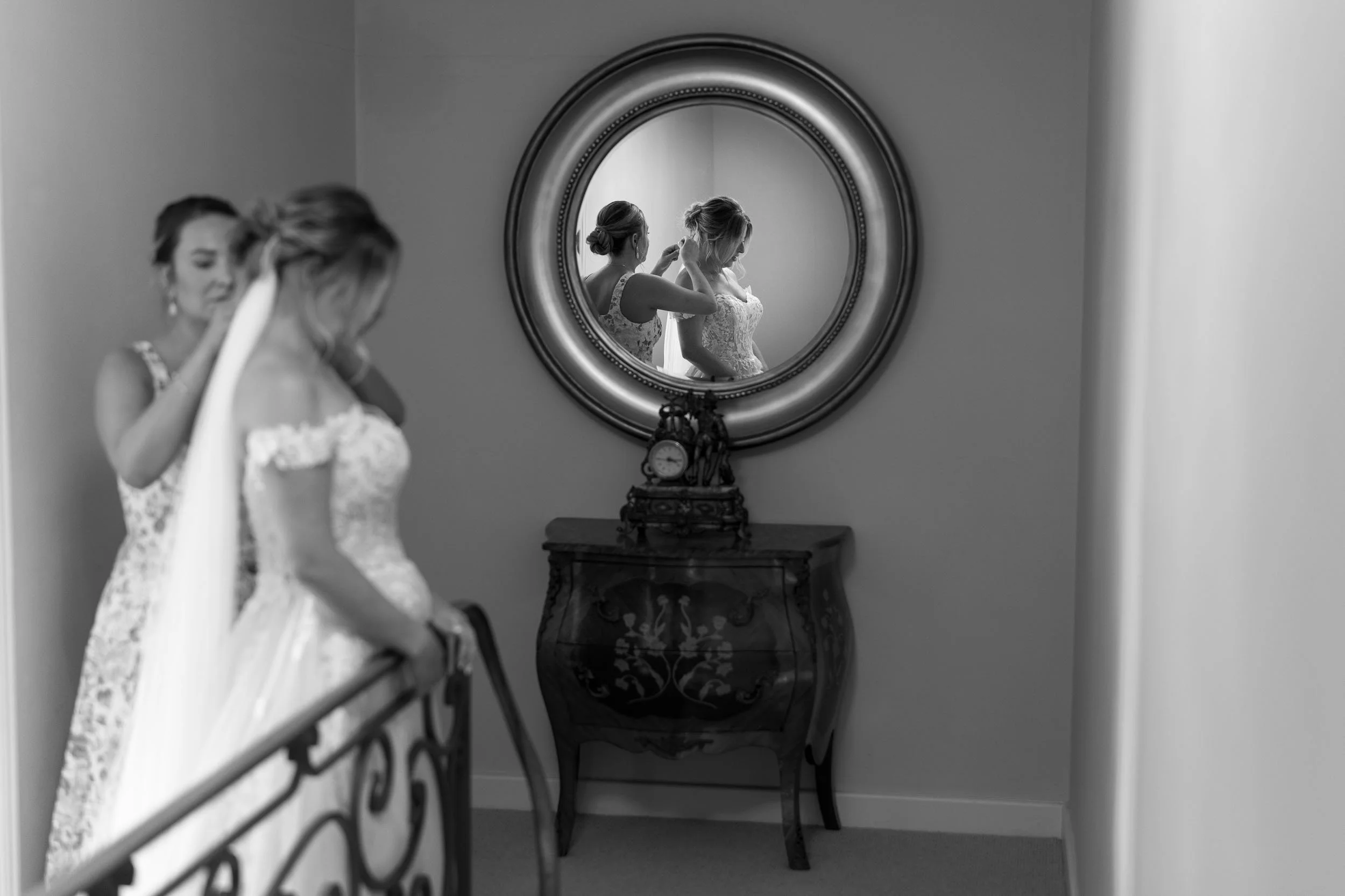 Candid photograph of the bride caught in a mirror reflection while getting ready