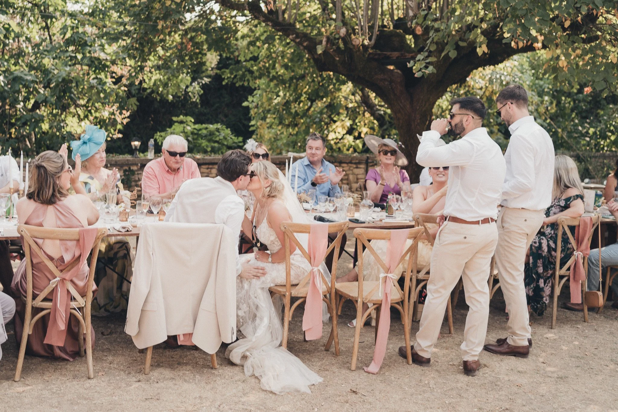 Guests gathered around long tables during an outdoor wedding meal in France.