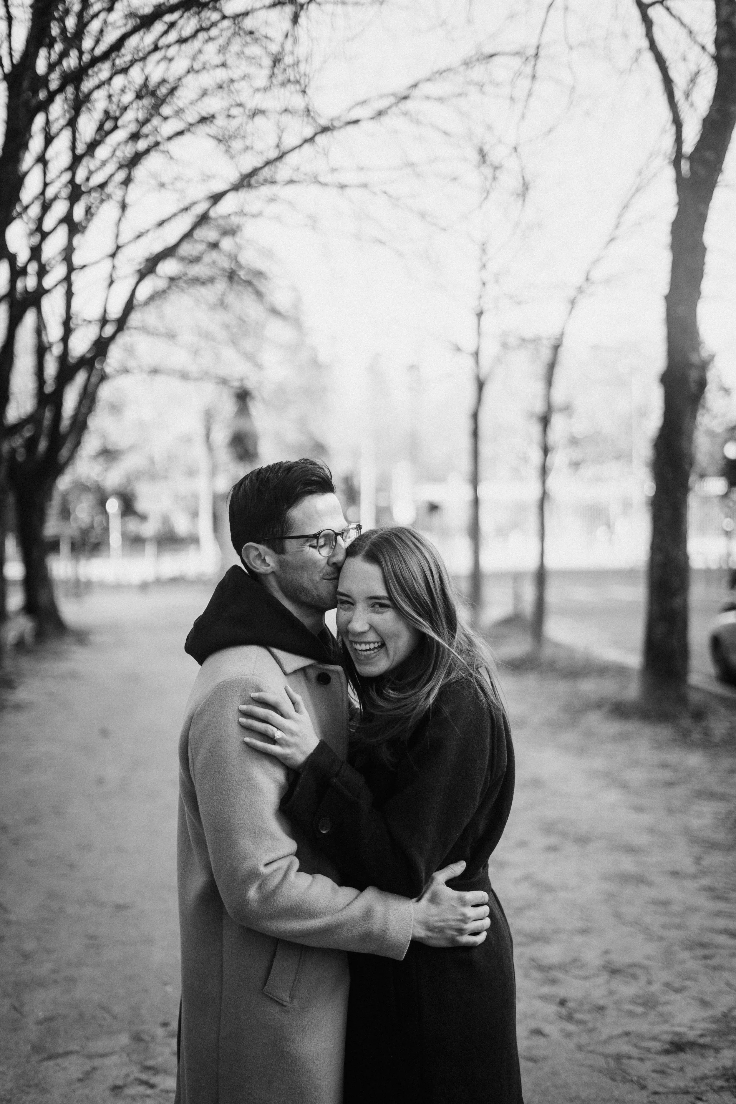 Black and white engagement photograph of a couple embracing quietly in Bordeaux