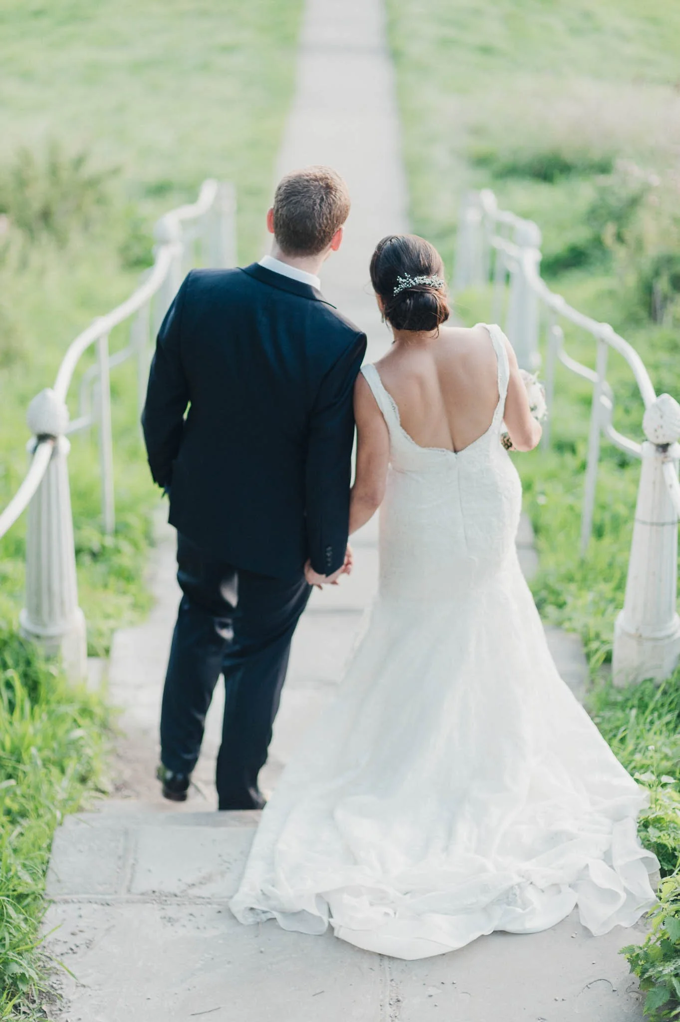 The couple walking hand-in-hand down a garden path during their portraits.