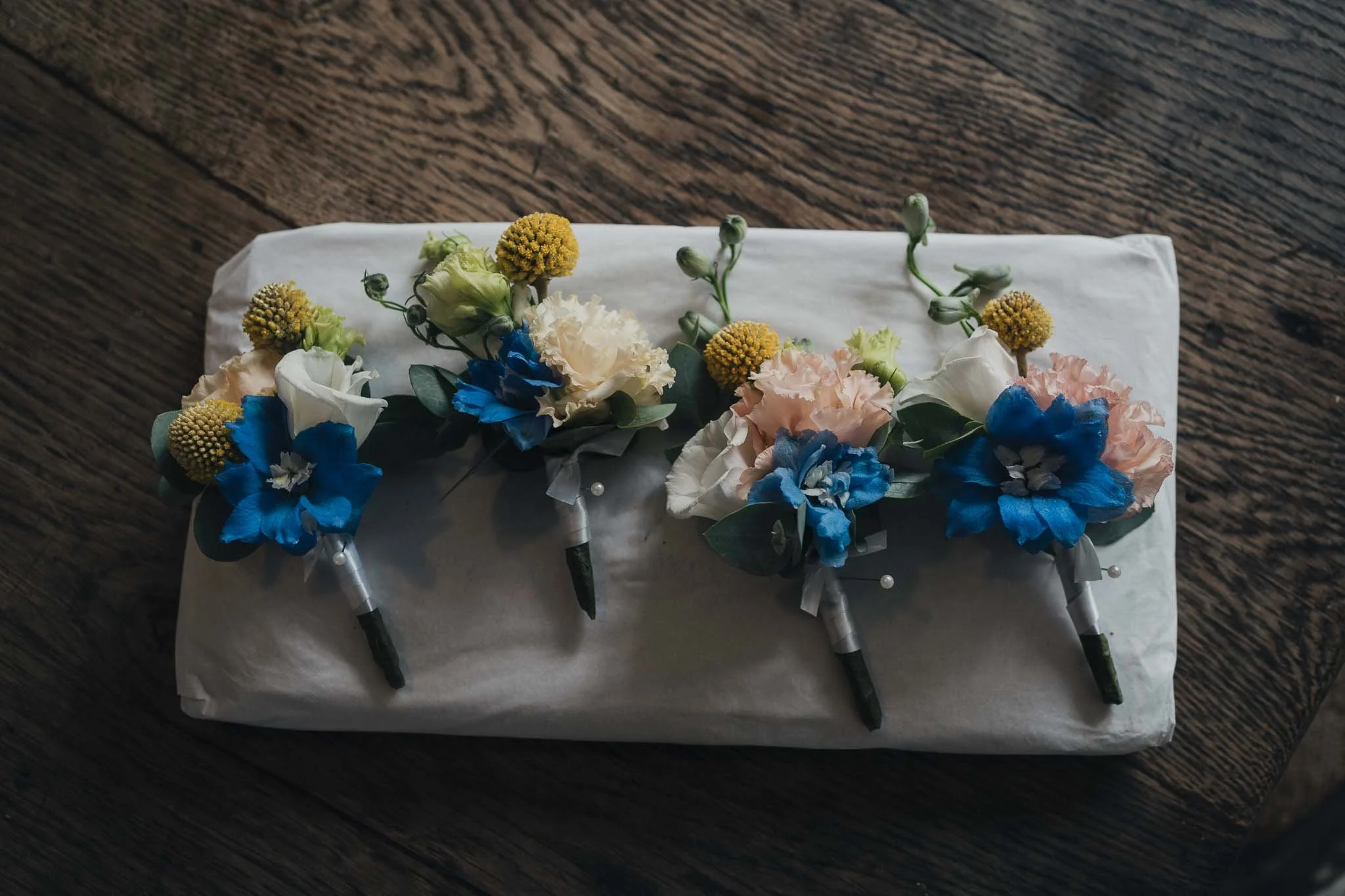 Groom’s buttonholes laid out on white fabric, ready before the wedding at Manoir de Longeveau.