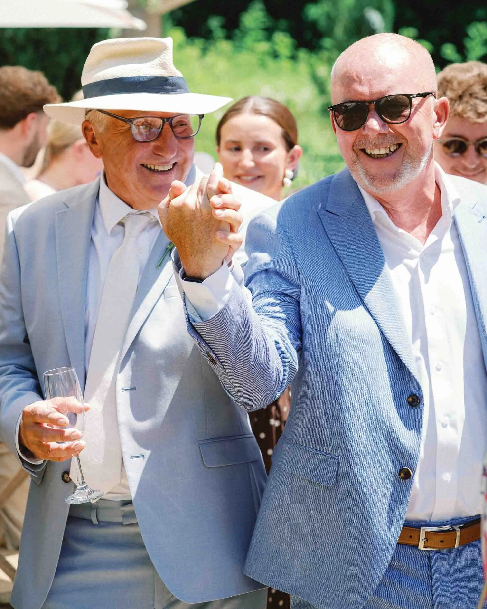 Two wedding guests toasting and laughing at Château du Raysse, Dordogne