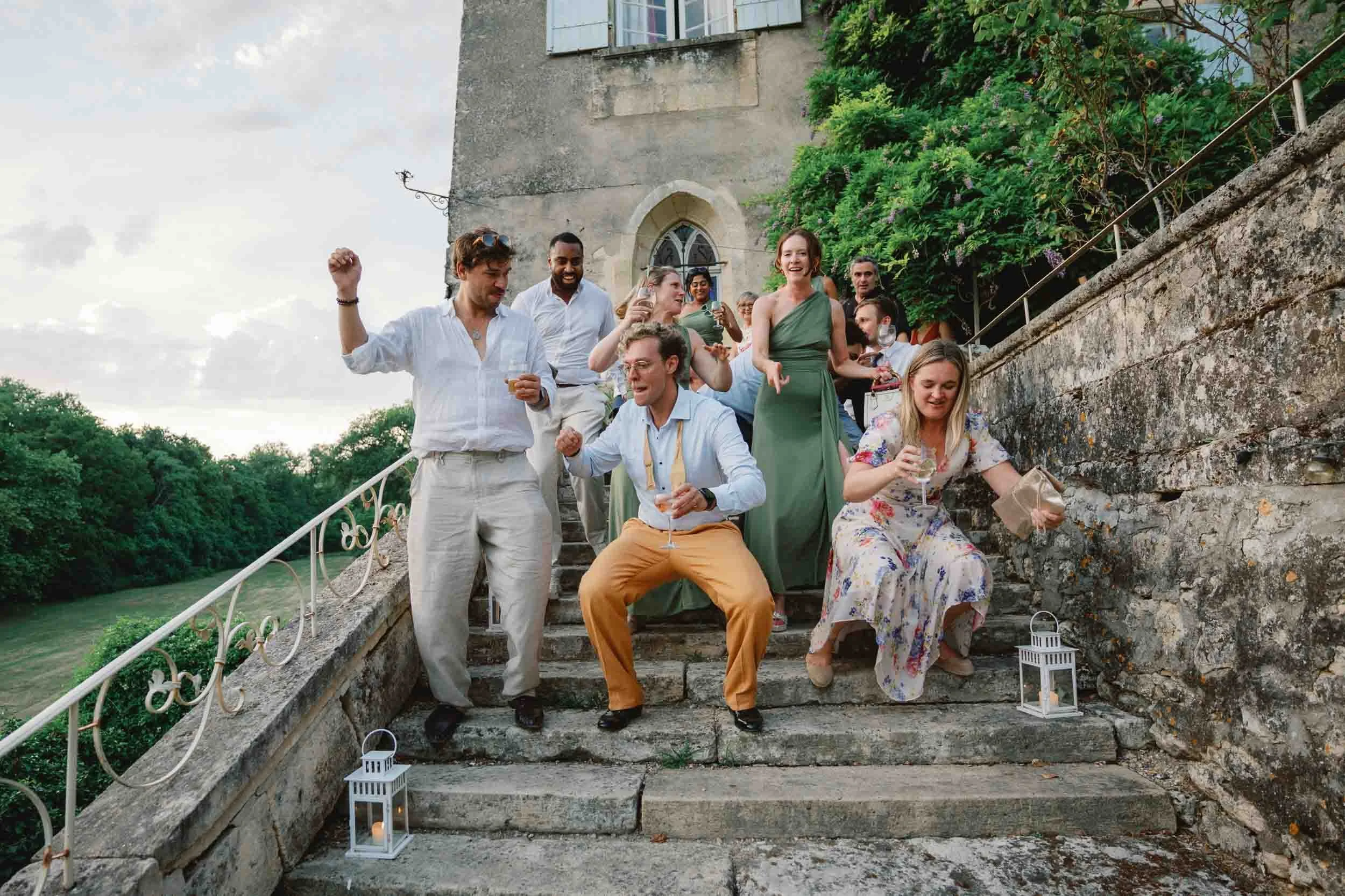 Groomsmen dancing on the stone steps at Château Lagorce, Bordeaux