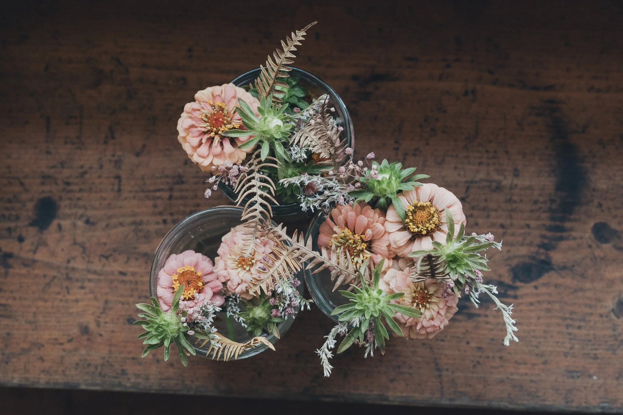 Close-up of the groom’s boutonniere and floral details laid out on a wooden table