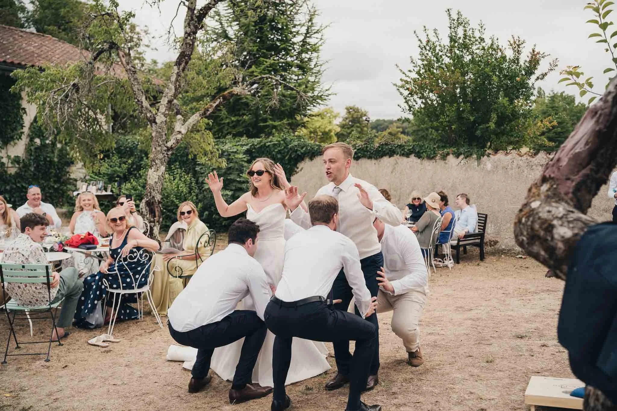 Wedding party forming a line-out for a playful rugby-themed moment on the lawn.