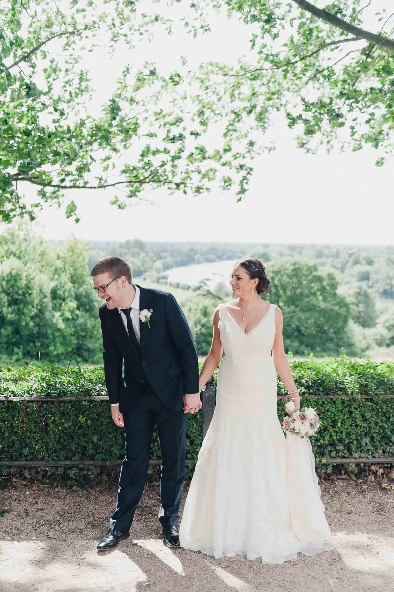 Bride and groom walking together outside the Richmond Hill Hotel, smiling in the afternoon light.