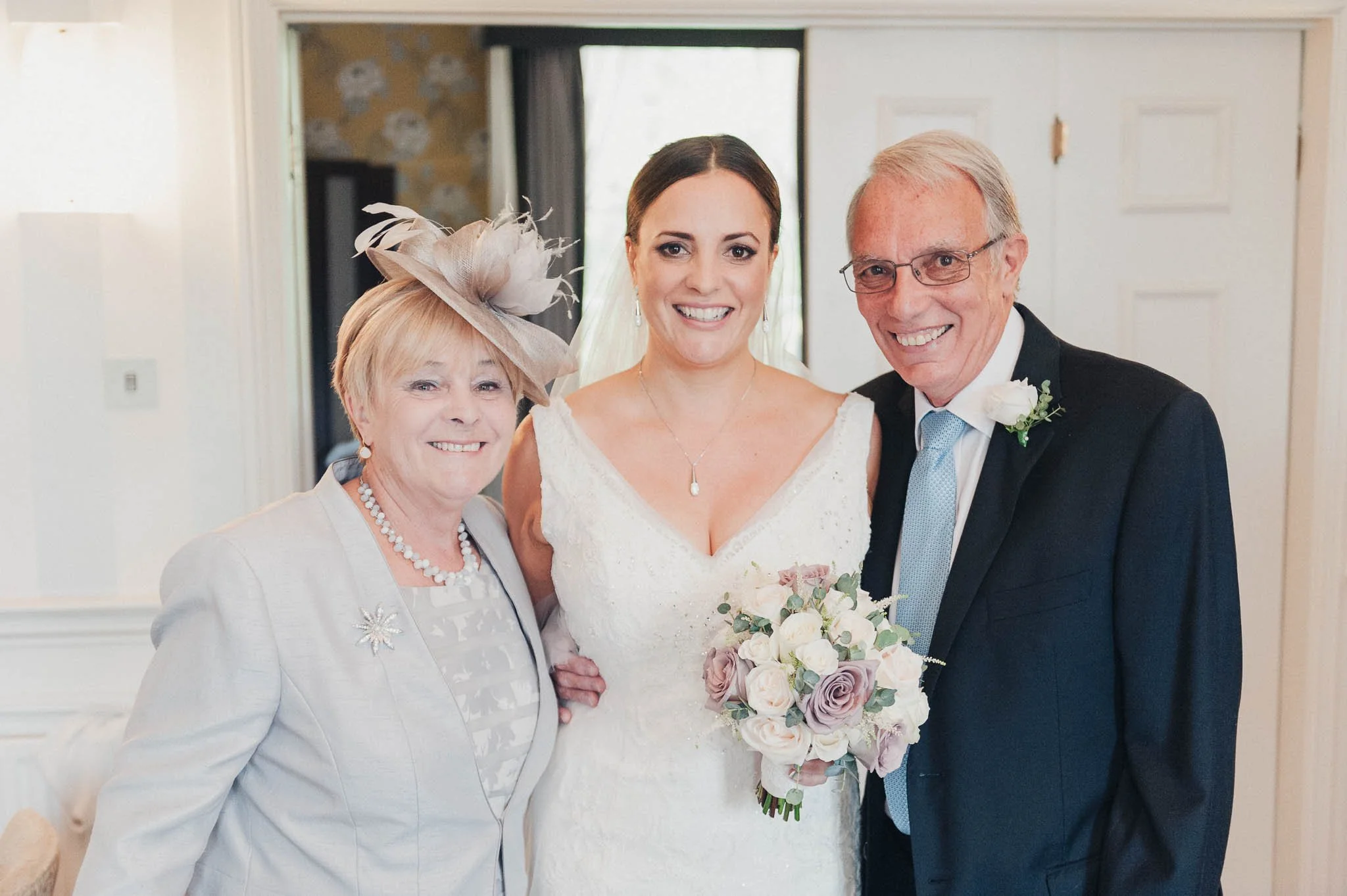 Bride posing with two family members before the ceremony, all smiling for the camera.