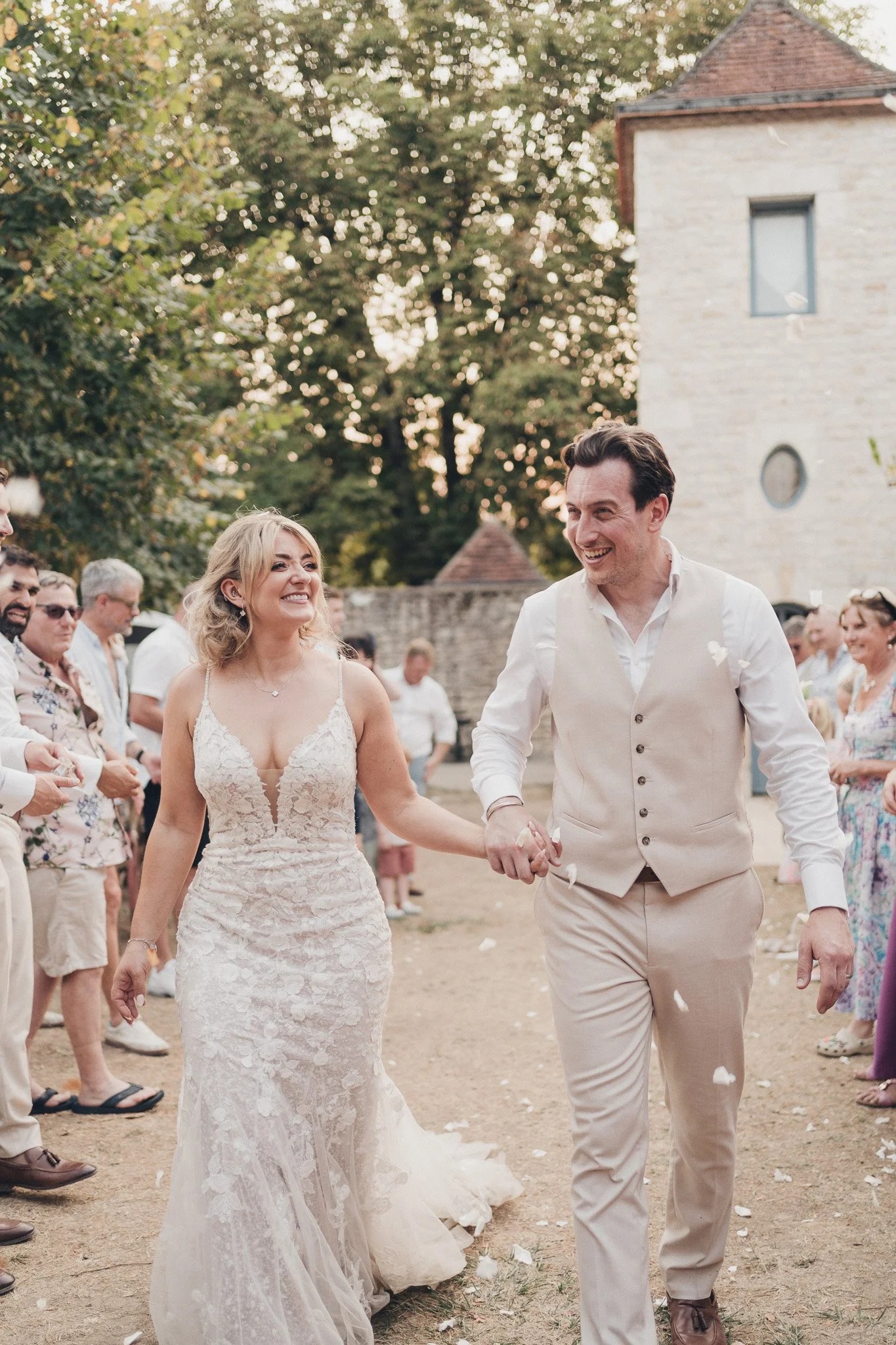 Newly married couple walking through the courtyard at their Dordogne wedding celebration.