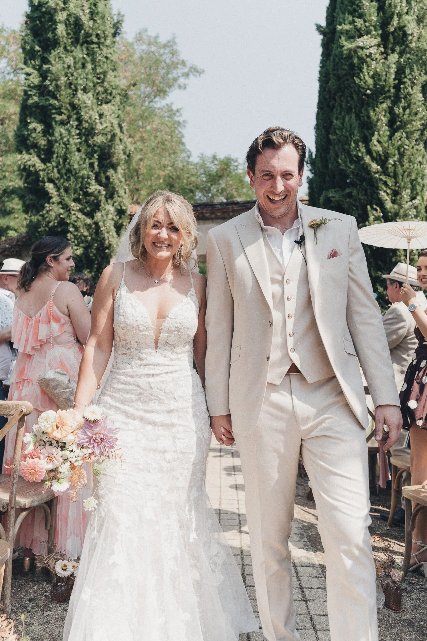 Newly married couple walking through the courtyard during their outdoor wedding in the Dordogne.