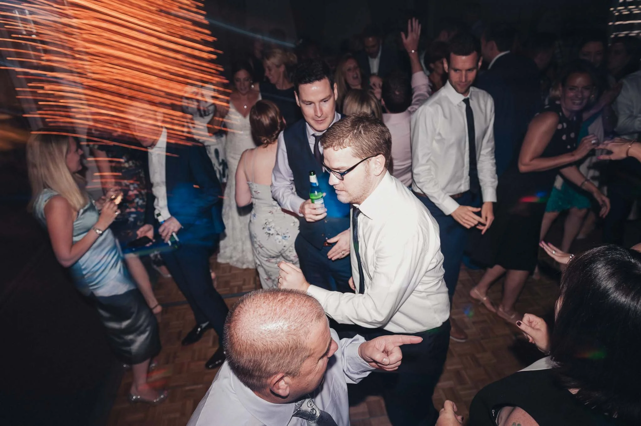 Guests dancing under warm lights with motion blur capturing the movement.