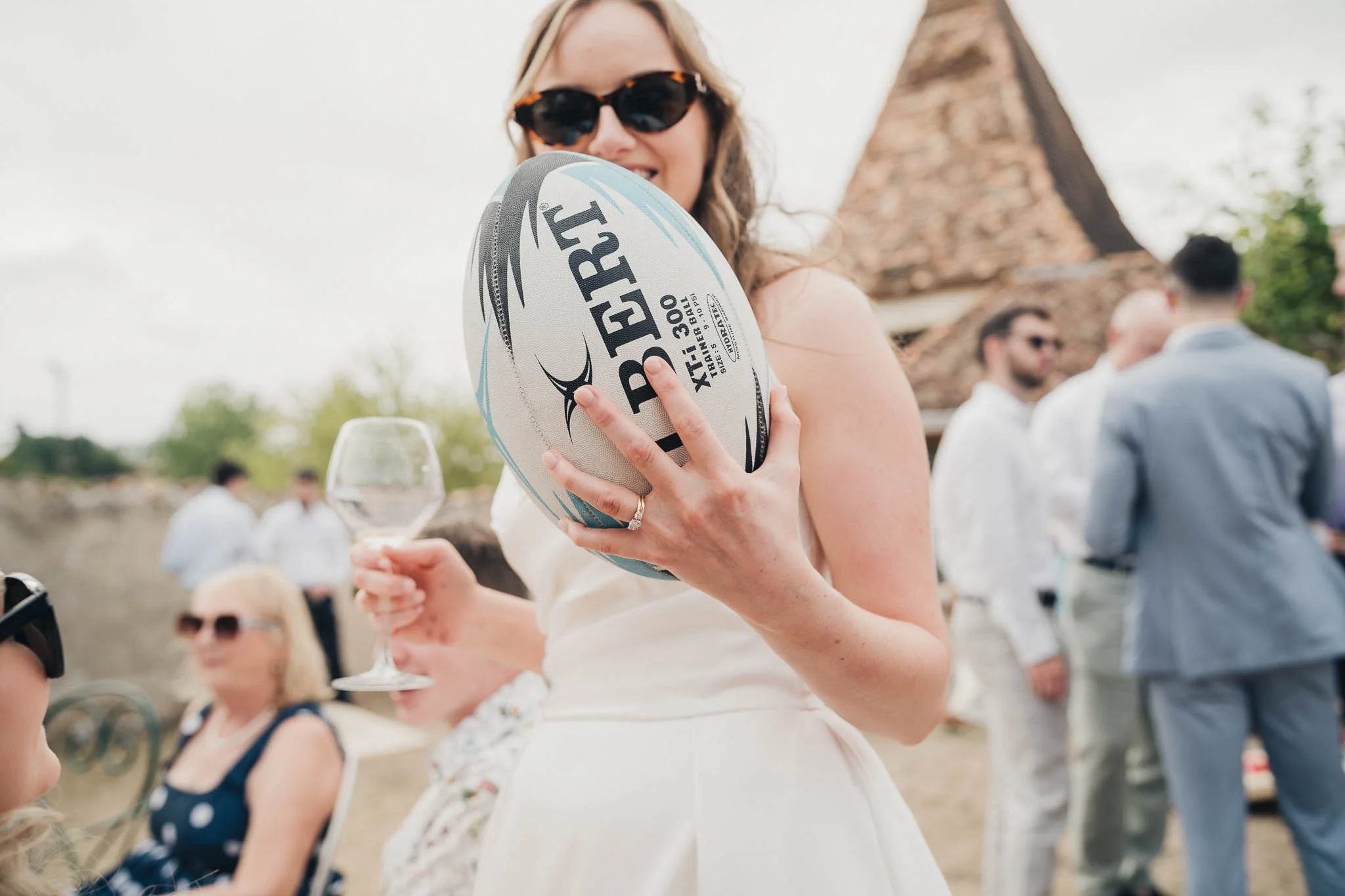 Close-up of the bride holding a personalised rugby ball during the reception.