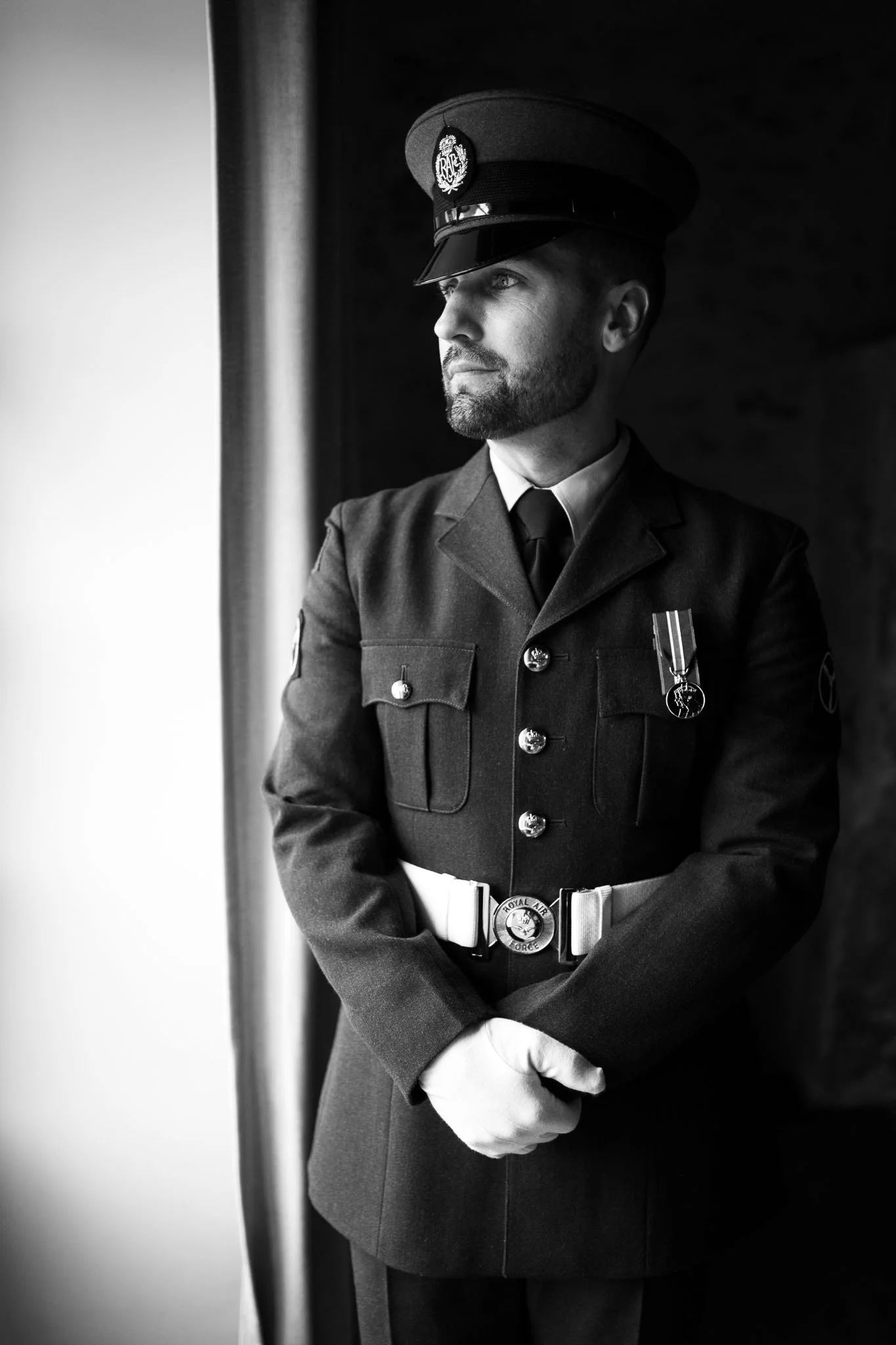 Black and white portrait of the groom in military dress uniform at Manoir de Longeveau, Charente