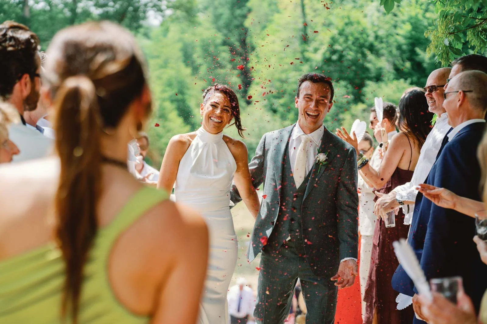 Bride and groom laughing through confetti after the ceremony at Château Lagorce, Bordeaux
