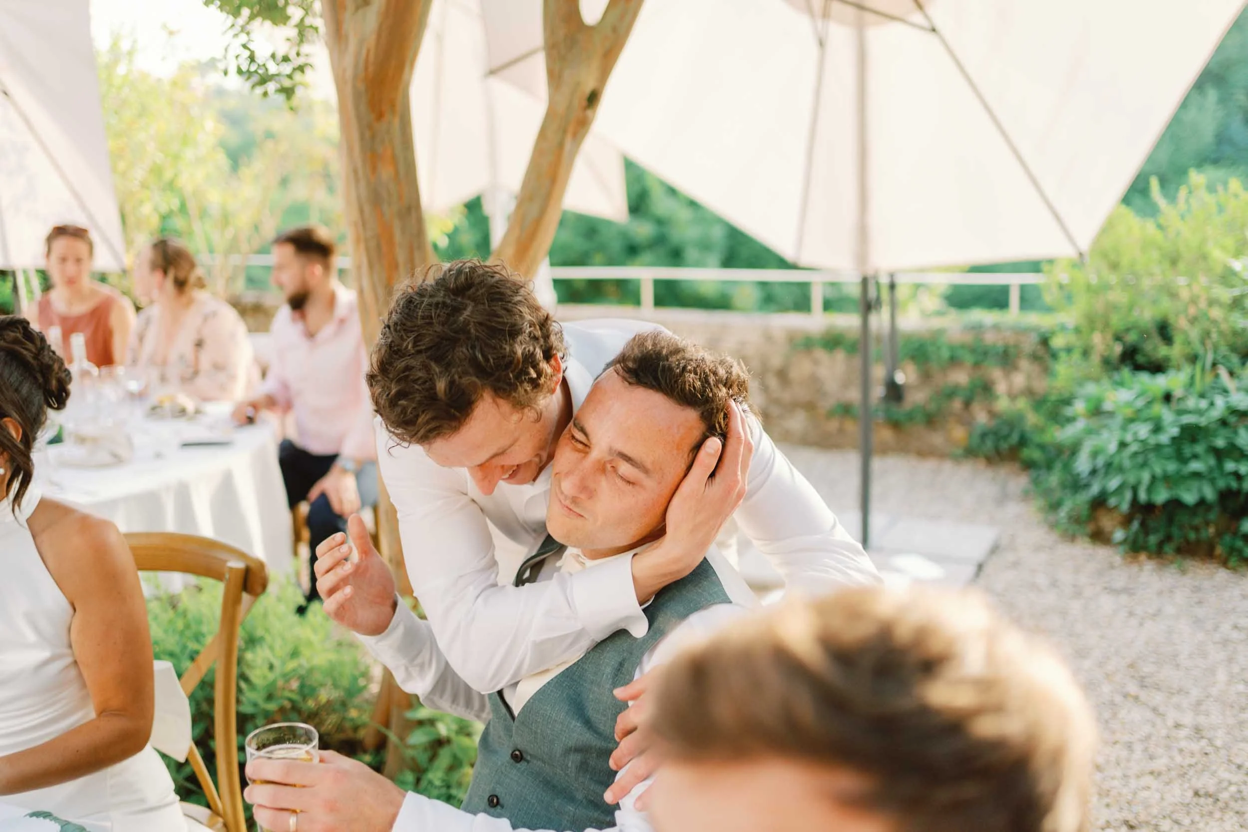 Groom embracing a groomsman at Château Lagorce, Bordeaux