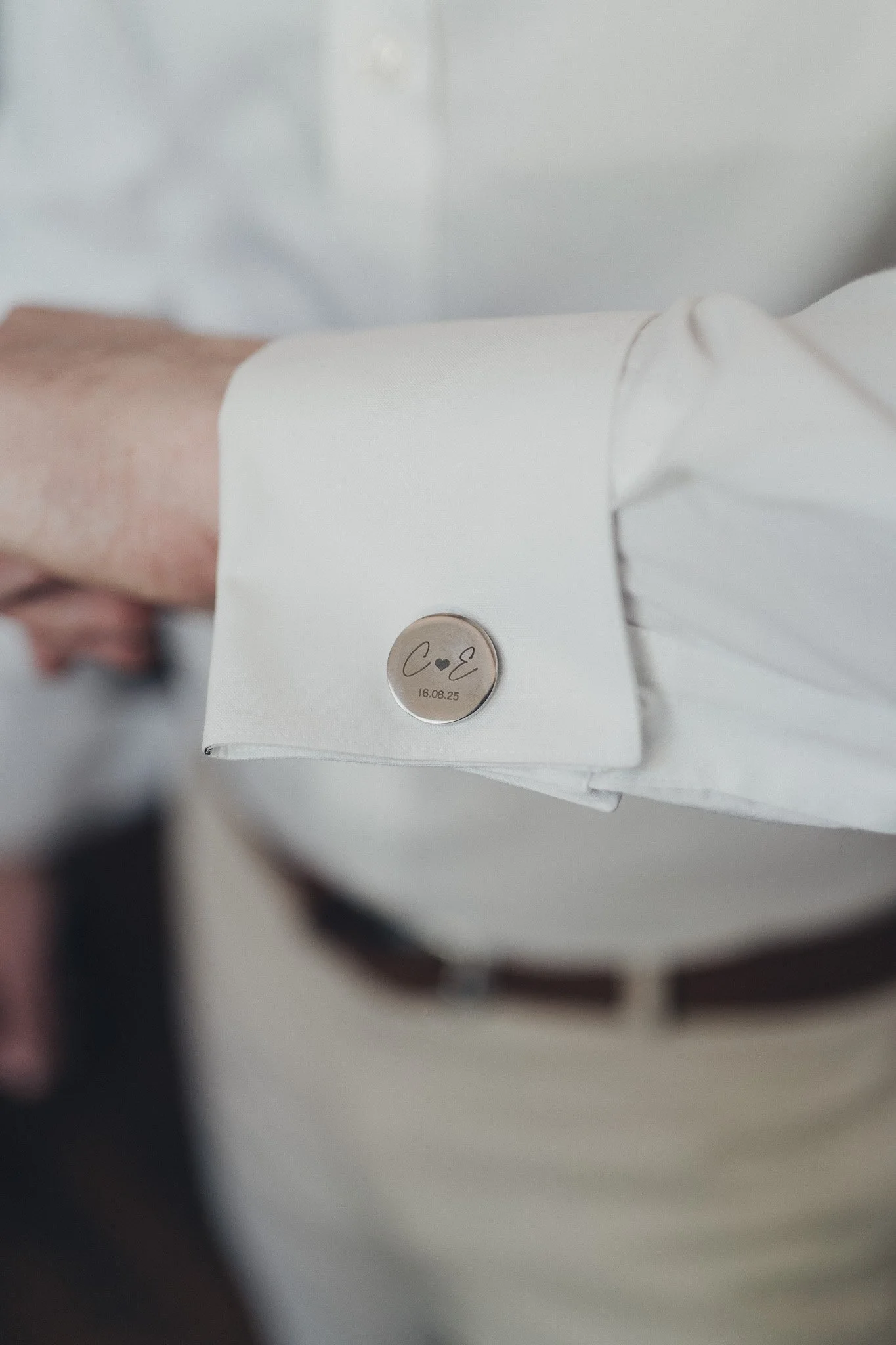 Close-up of the groom’s personalised cufflink during morning preparations.