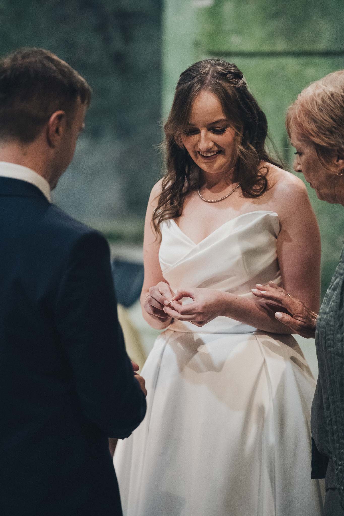 Bride placing a ring on the groom’s finger during the ceremony at the Église Souterraine Saint-Jean.