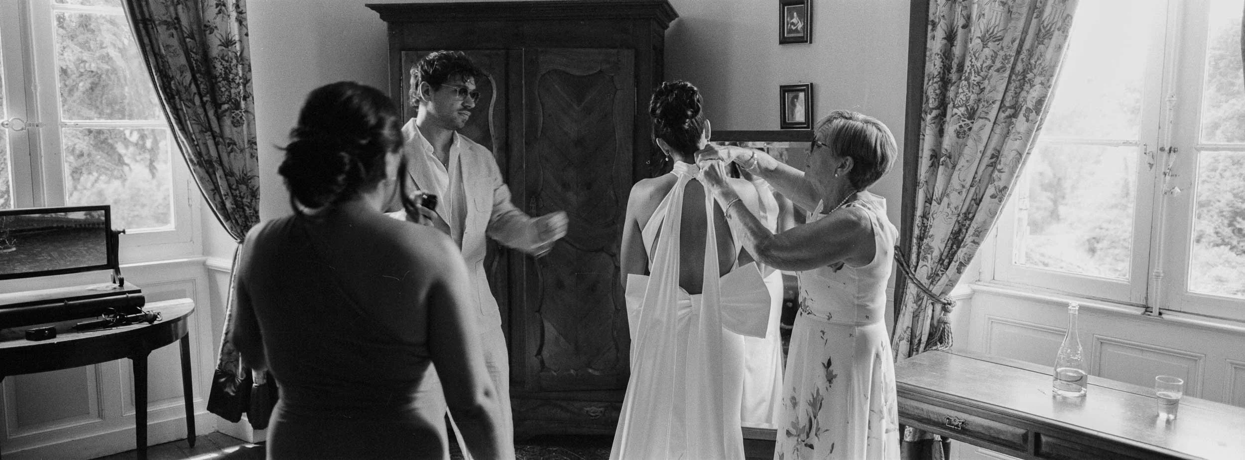 Panoramic film photograph on Hasselblad XPan of the bride's dress being tied at Château Lagorce, Bordeaux