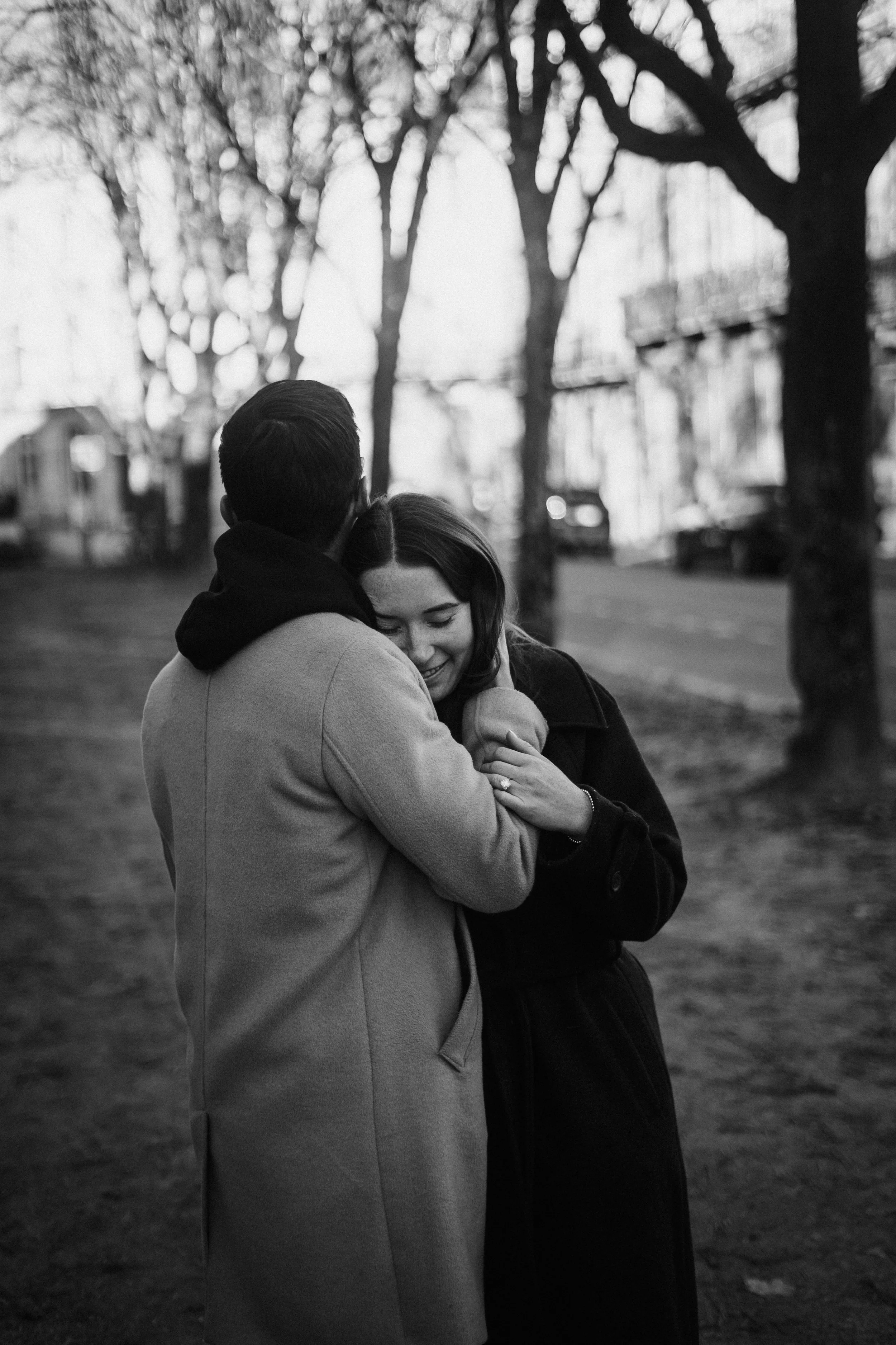 Black and white photograph of newly engaged couple holding each other quietly after a proposal in Bordeaux.