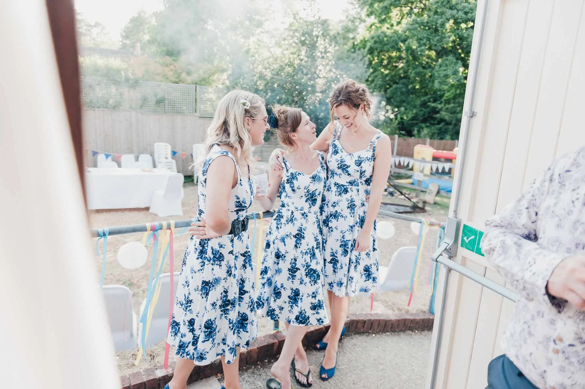Bridesmaids chatting together outside on the balcony during the reception.