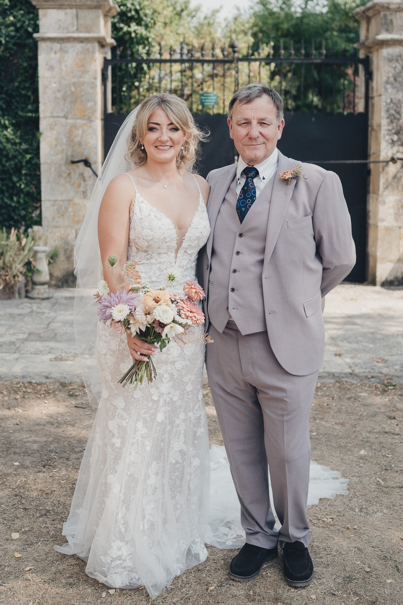 Bride standing with her father for a portrait before the ceremony.