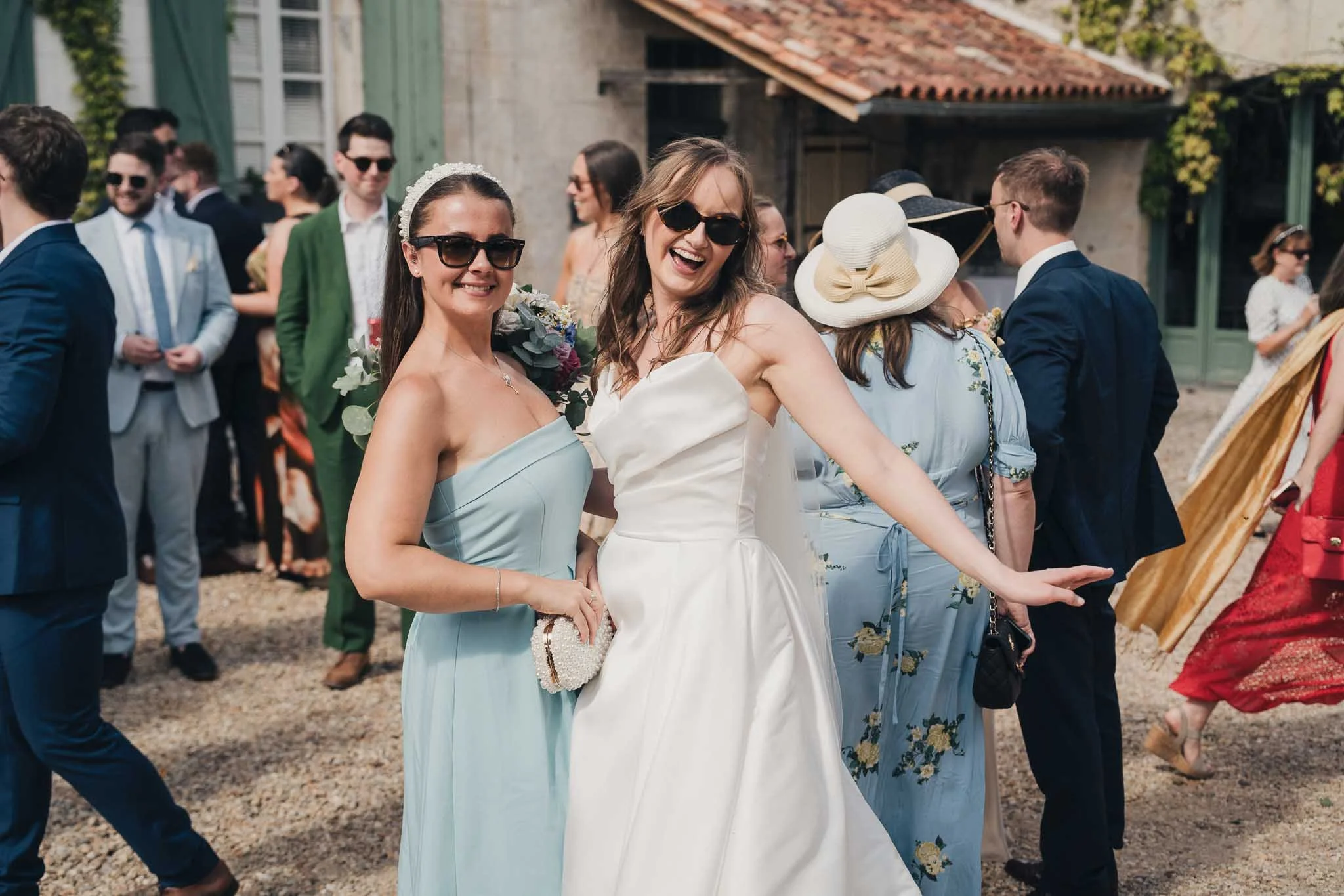 Bridesmaid and bride laughing together during the reception at Manoir de Longeveau.