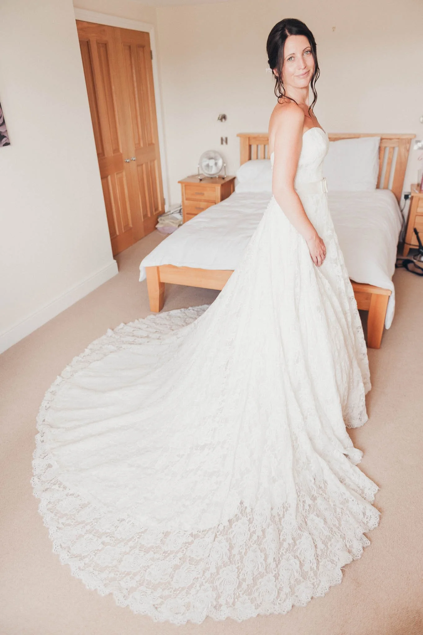 The bride’s in her dress wedding dress portrait showing the full lace train.
