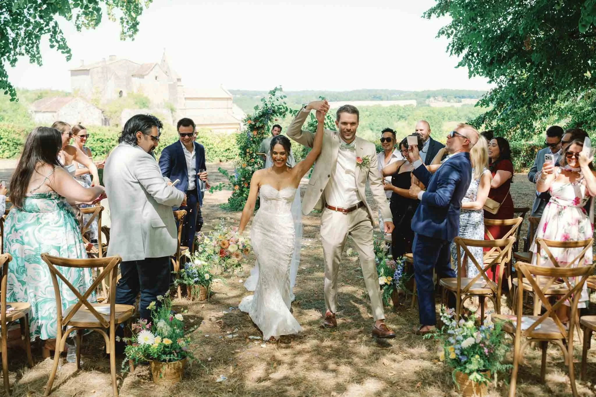 Bride and groom walking through confetti at Château de Sainte Croix, Dordogne