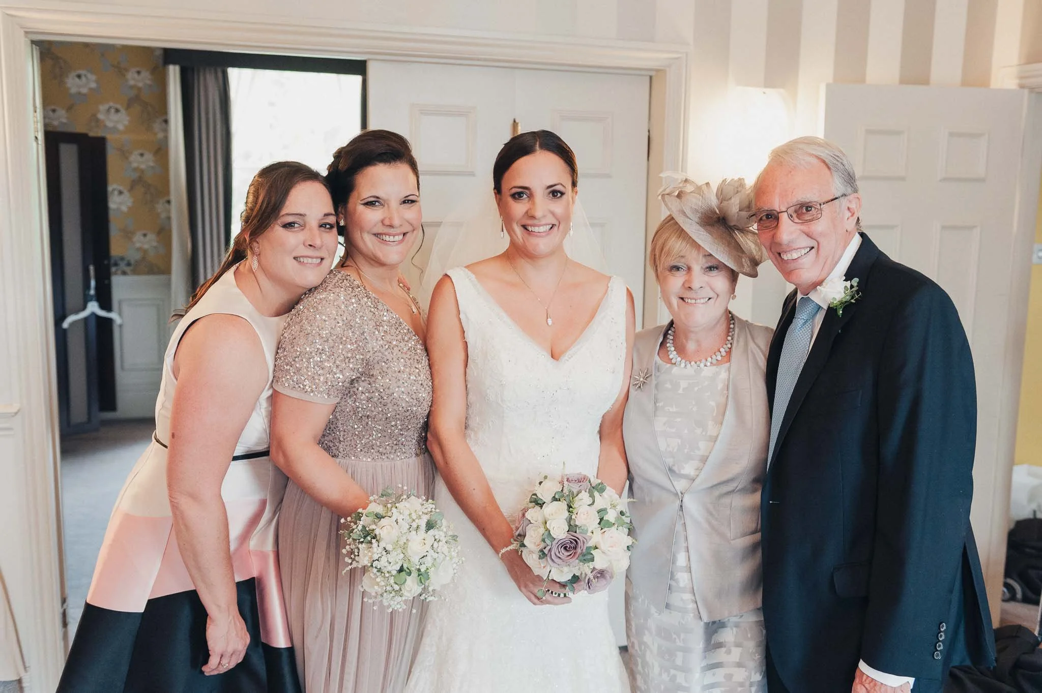 Bride posing with bridesmaids and close family, all dressed and ready for the ceremony.