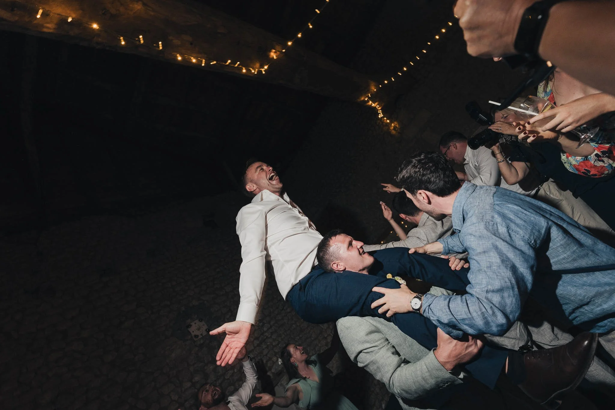 Groom being lifted into the air on the dancefloor during the evening party at Manoir de Longeveau.
