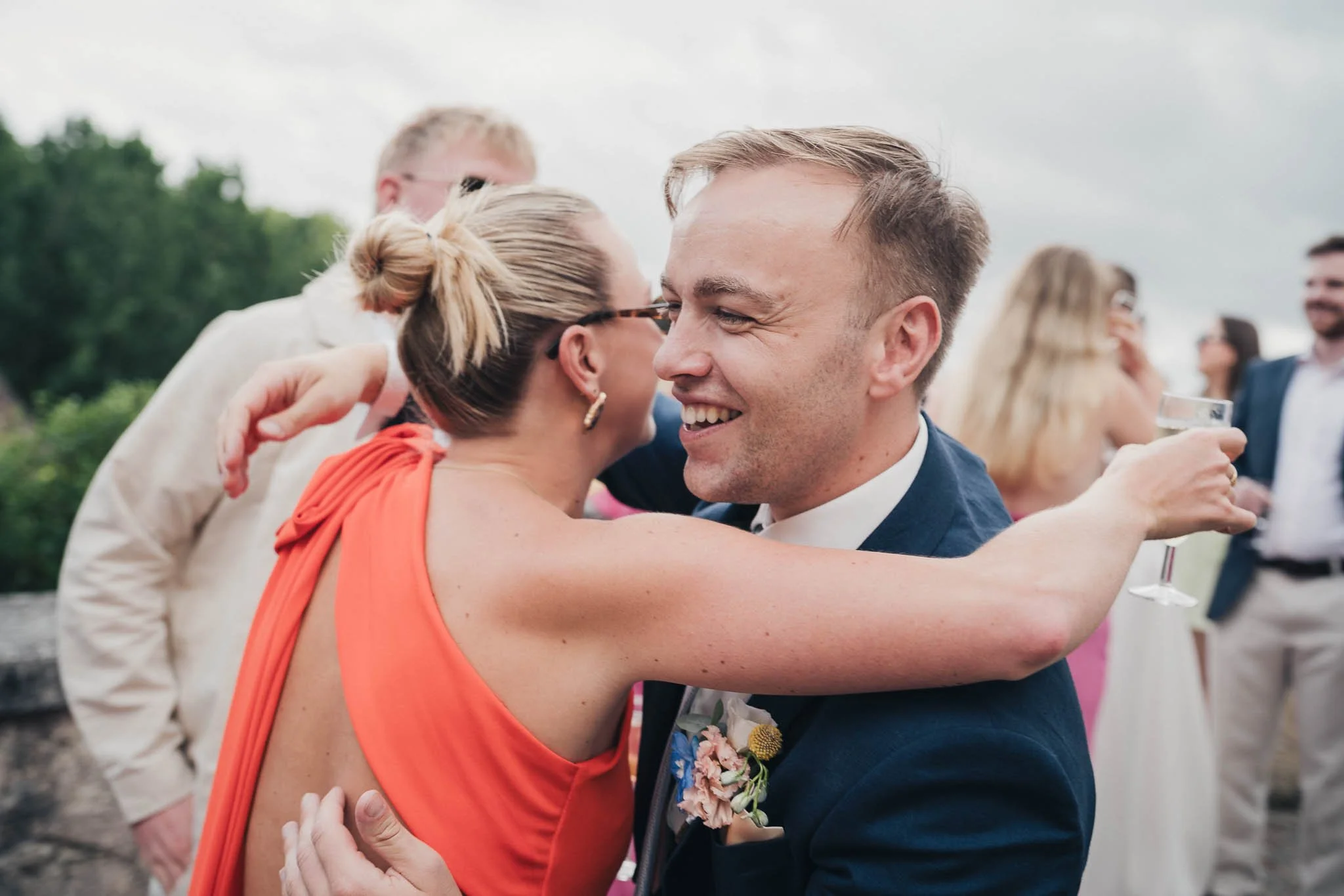 Groom hugging a guest during the reception at Manoir de Longeveau.