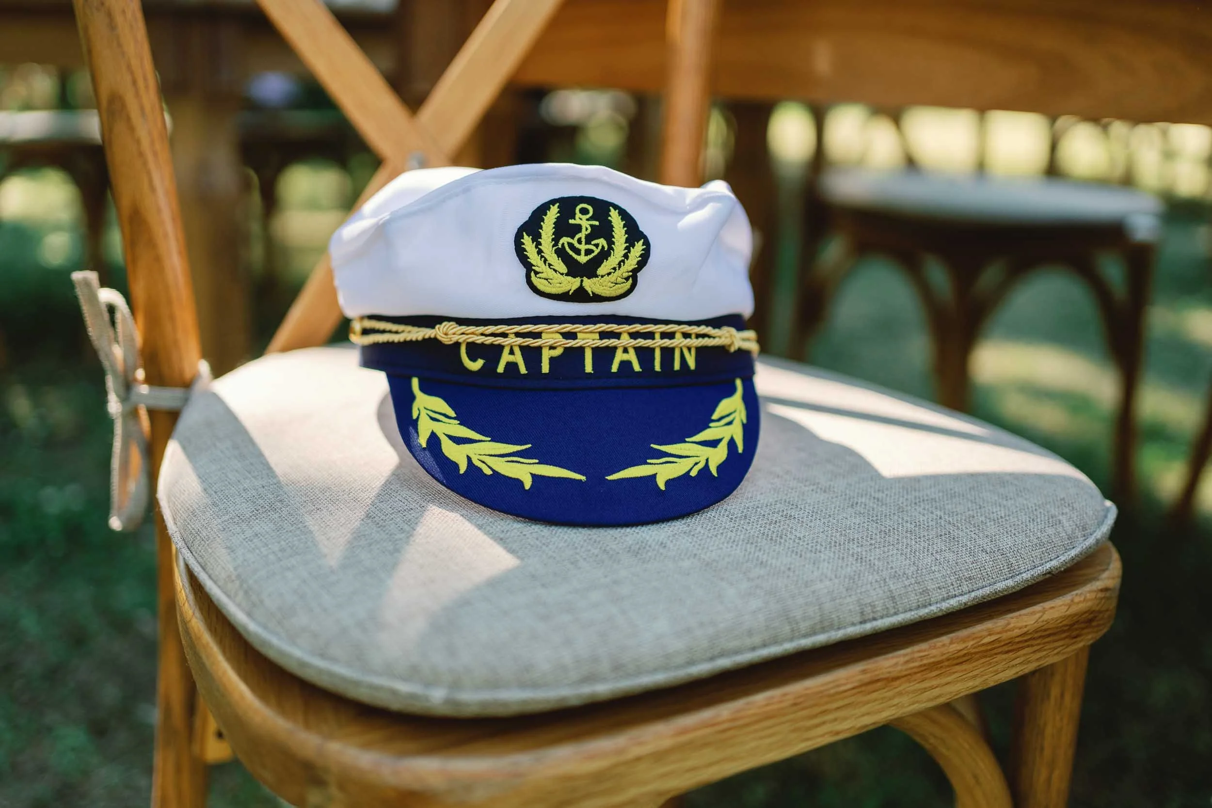 A captain's hat resting on a ceremony chair at Château de Panisseau, Dordogne
