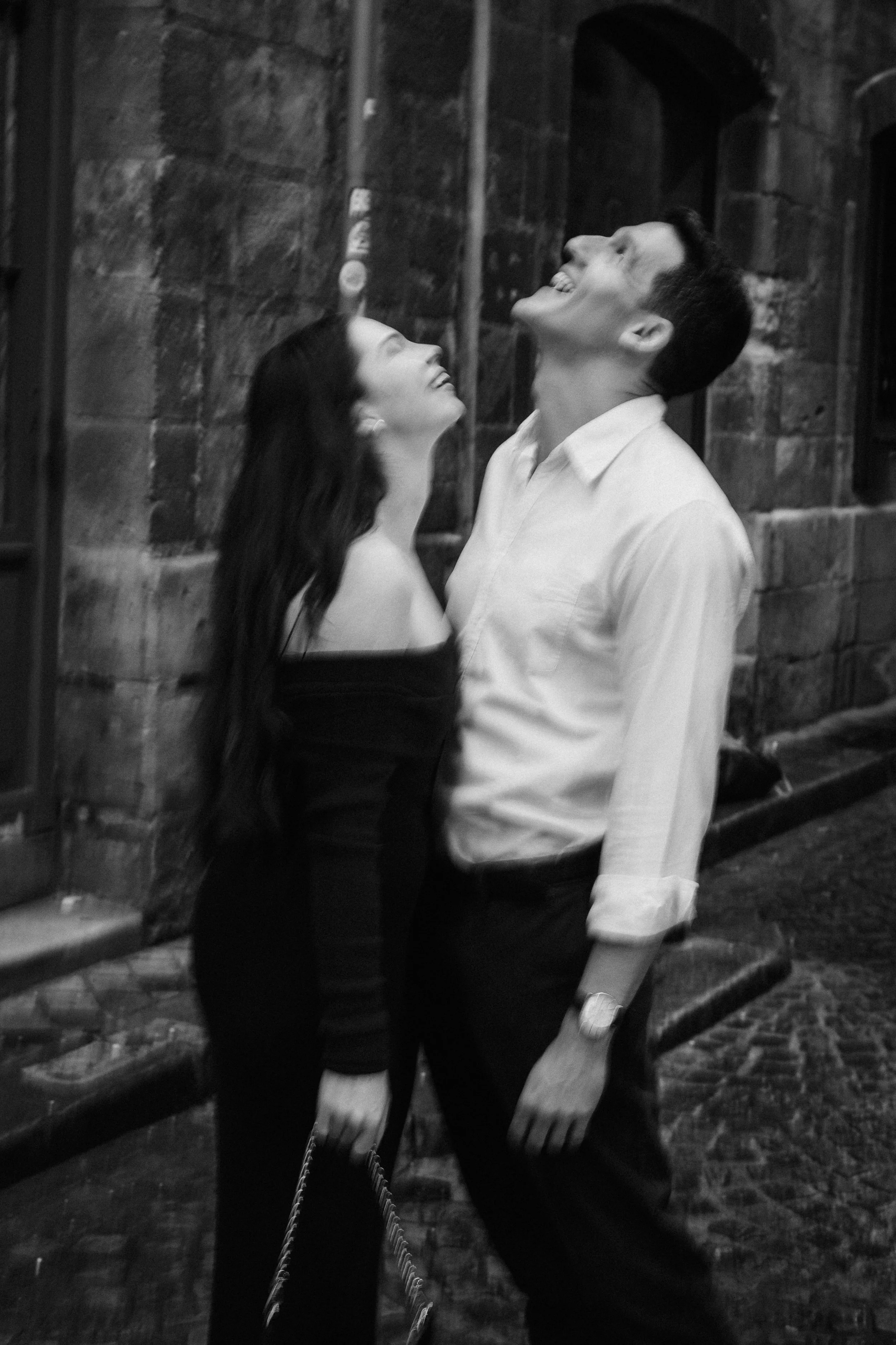 Black and white portrait of couple laughing together during a relaxed engagement shoot in Bordeaux.