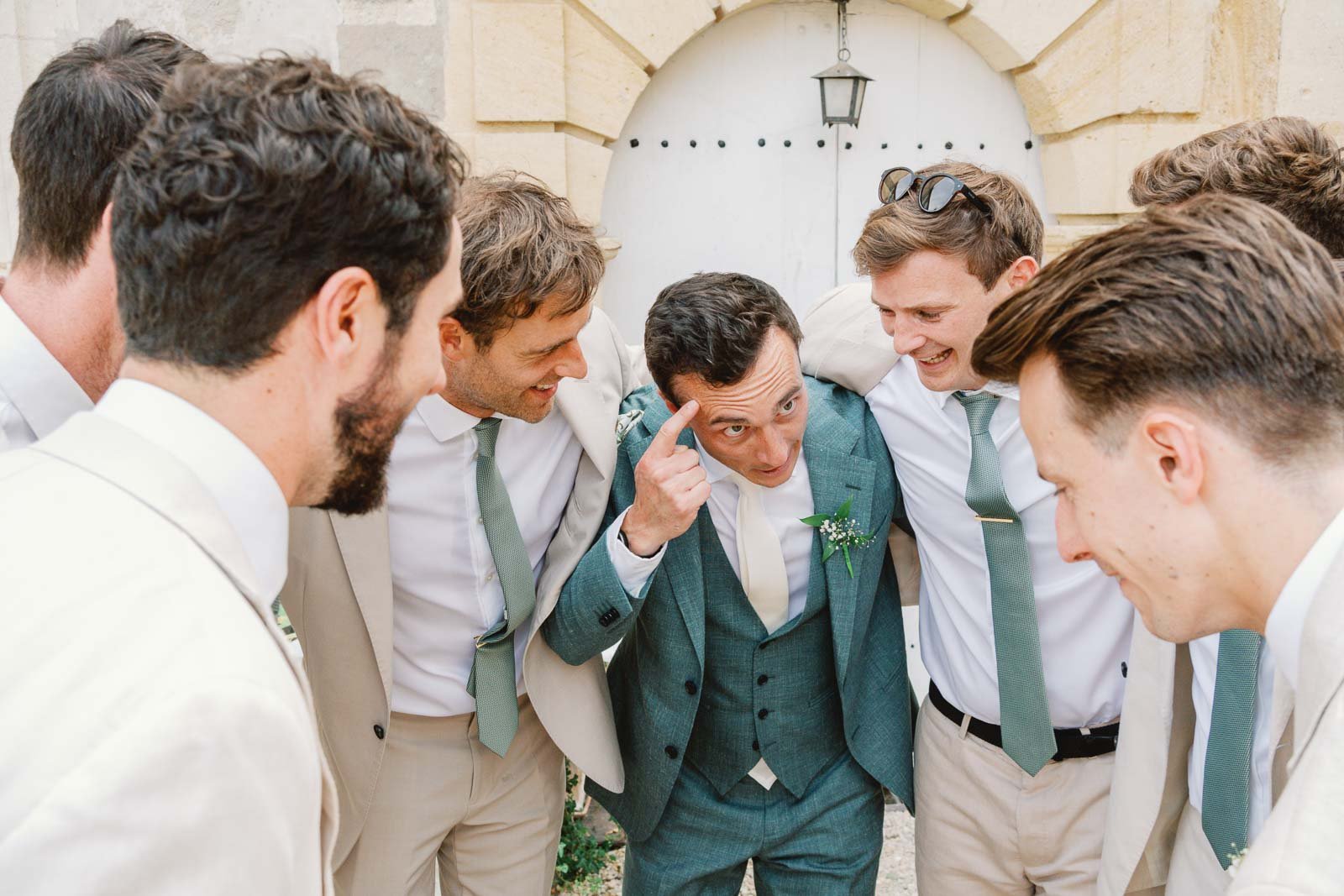 Groomsmen crowding around the groom after the ceremony at Château Lagorce