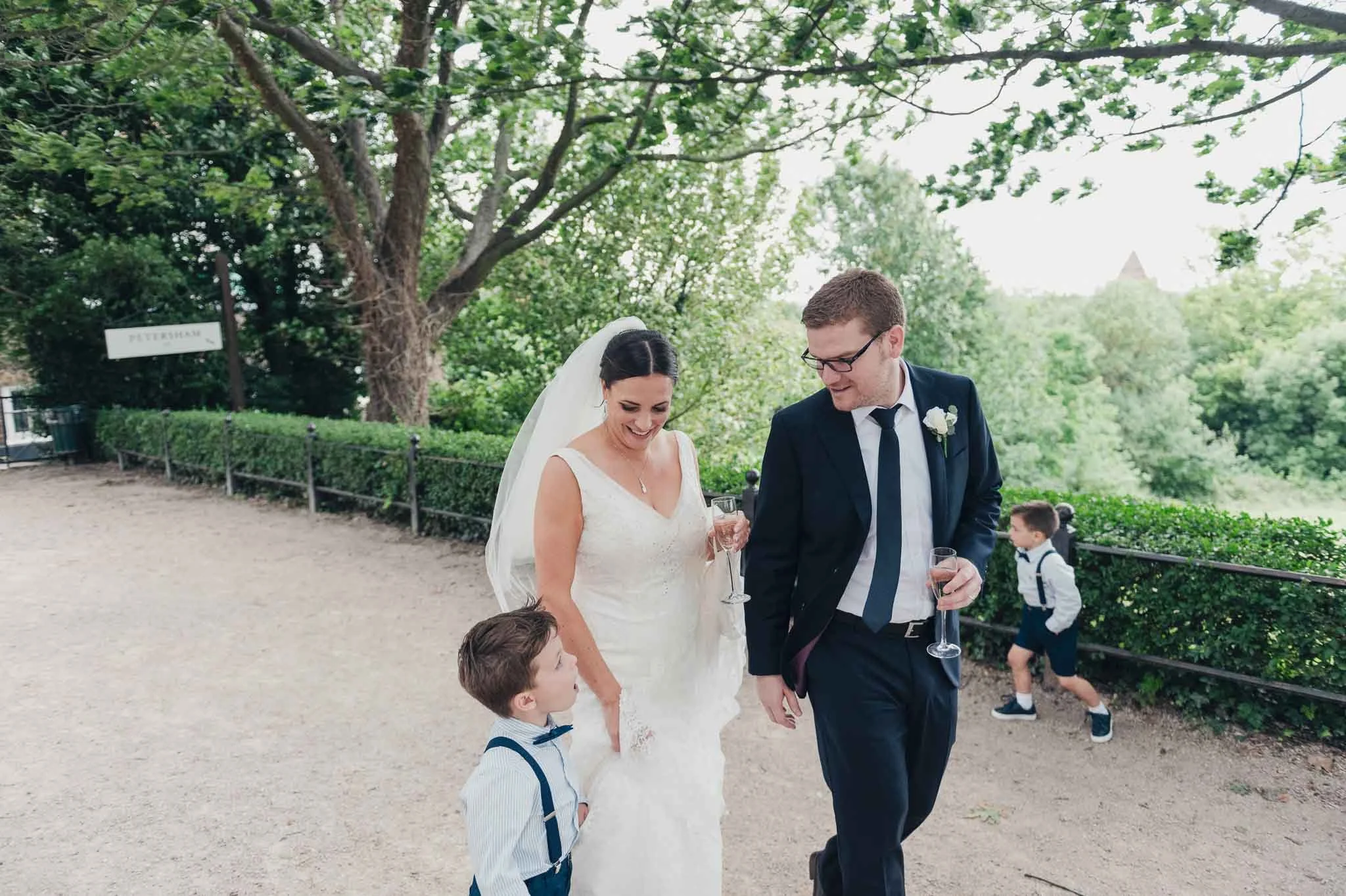 Bride and groom walking outside with a young child after the ceremony, enjoying a quiet moment together.