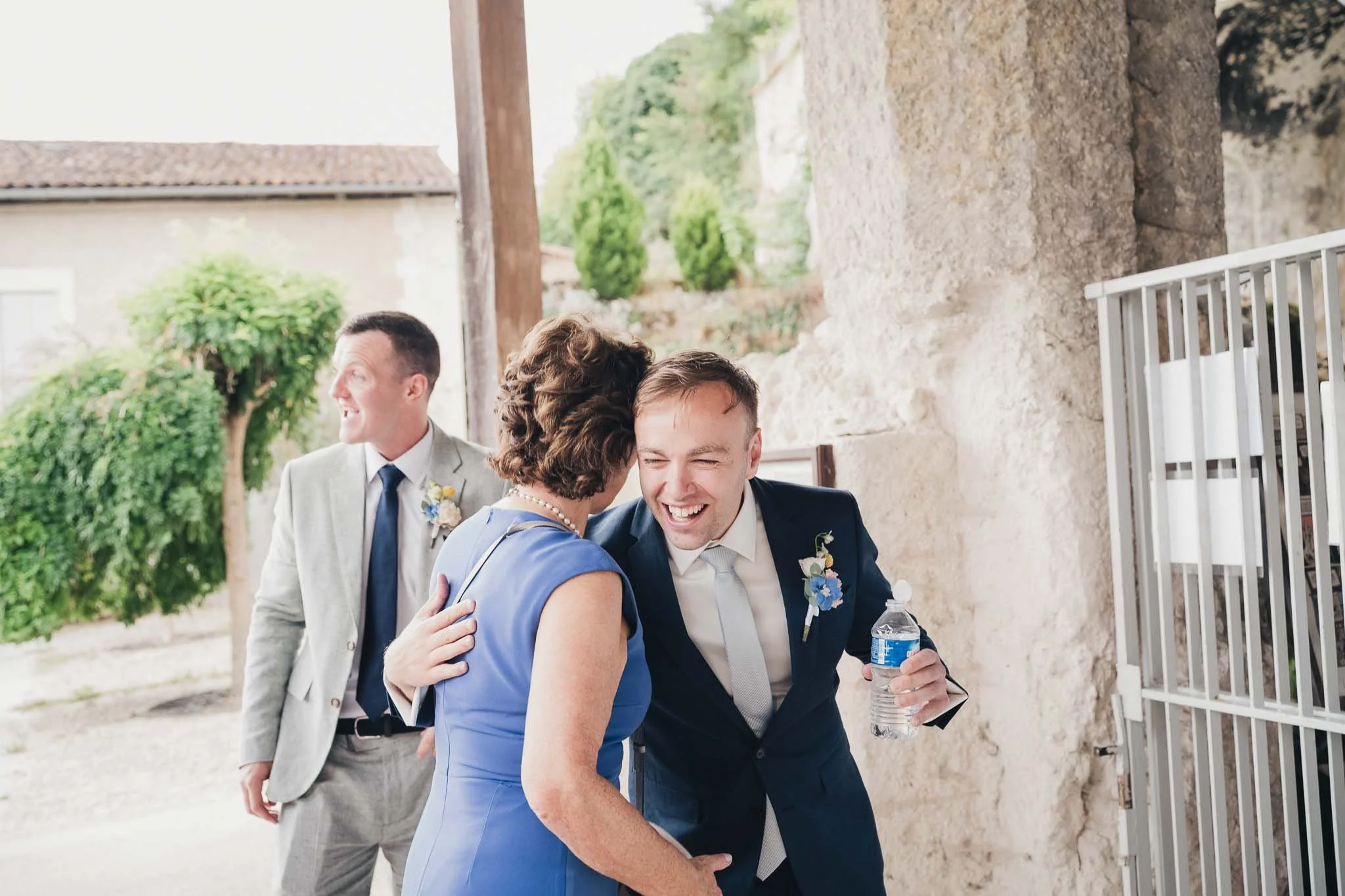 Groom greeting a guest with a hug outside the ceremony.
