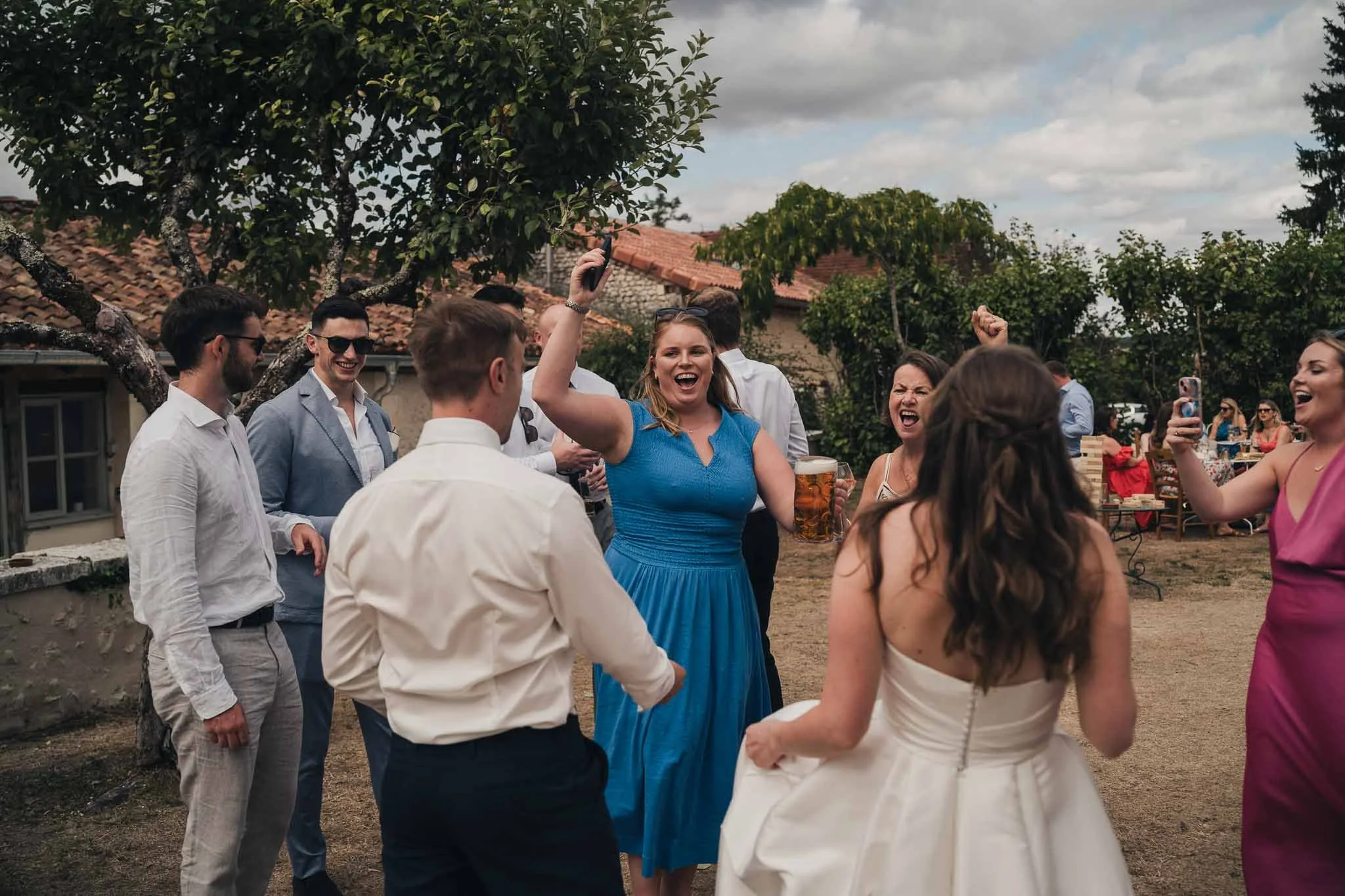 Guests dancing and celebrating outdoors during the reception at Manoir de Longeveau.
