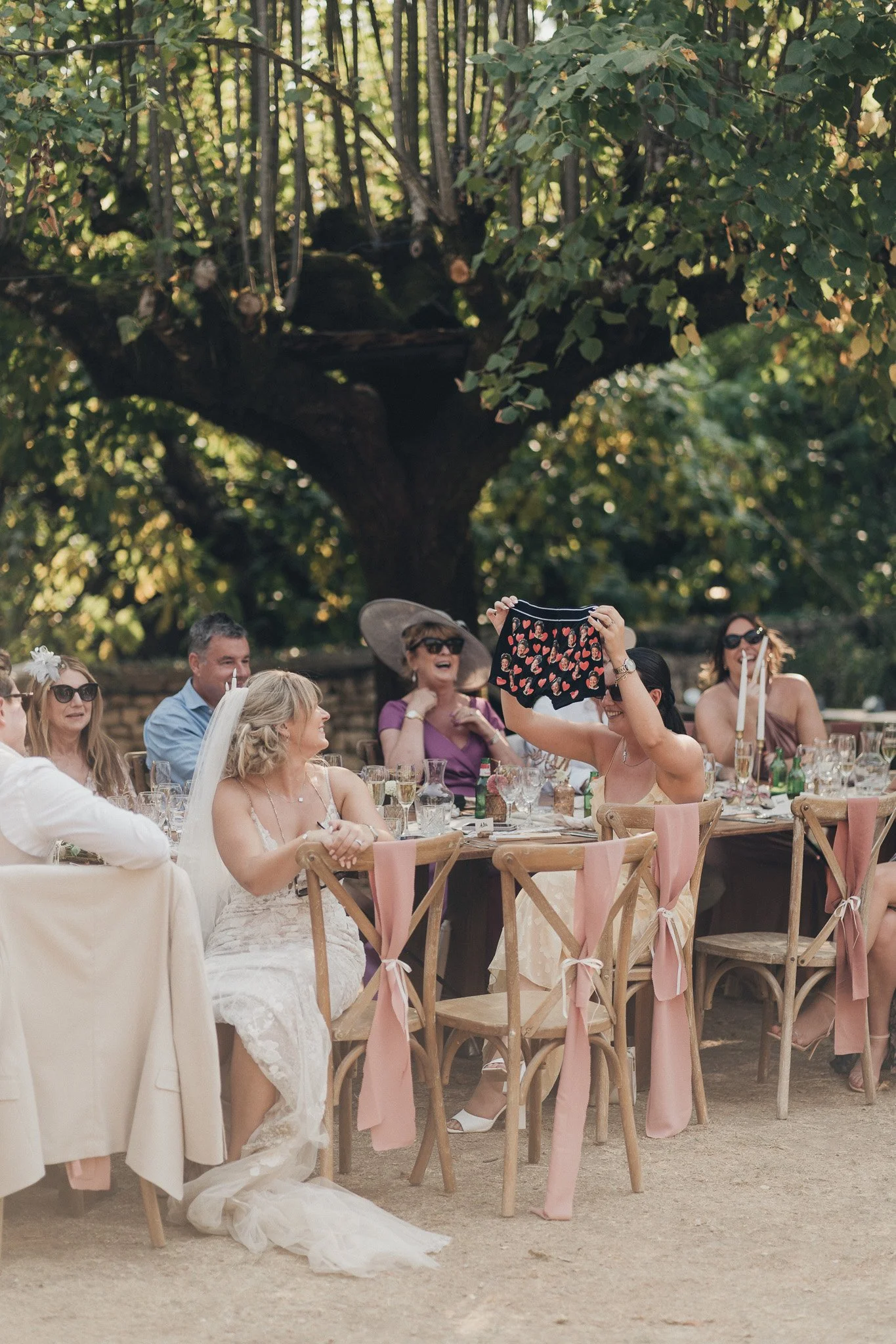 Guests taking photos and chatting at an outdoor wedding dinner in southwest France