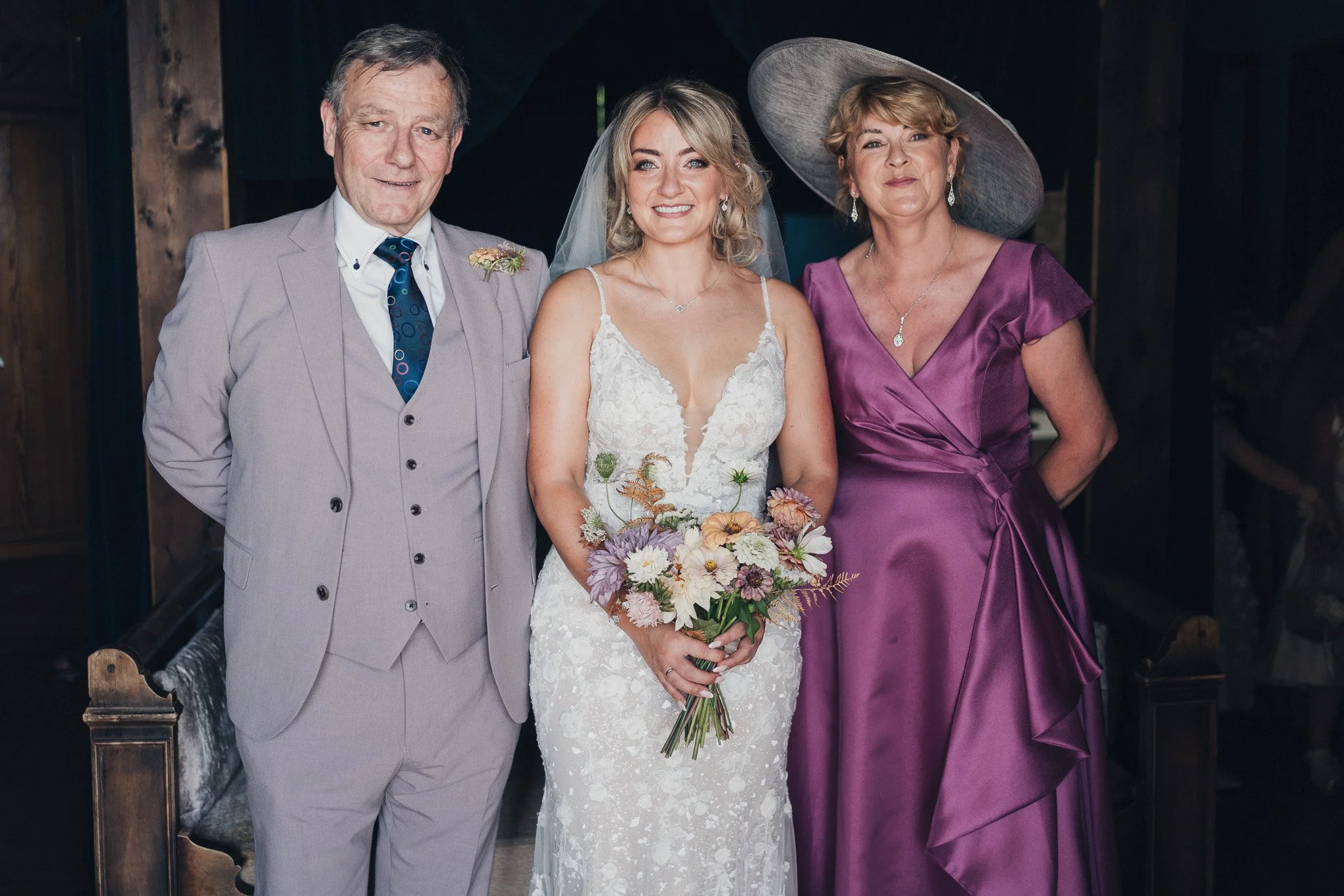 Bride standing with her parents for a portrait before the ceremony