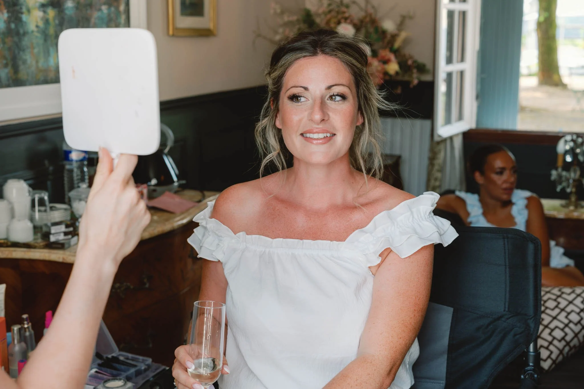 Bride checking her makeup in the mirror at Paradis des Vignes, Charente