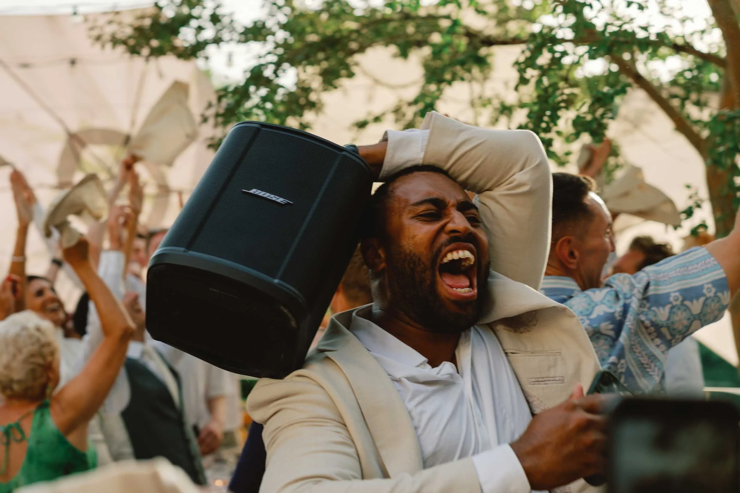 A wedding guest dancing with a speaker held overhead at Château Lagorce, Bordeaux