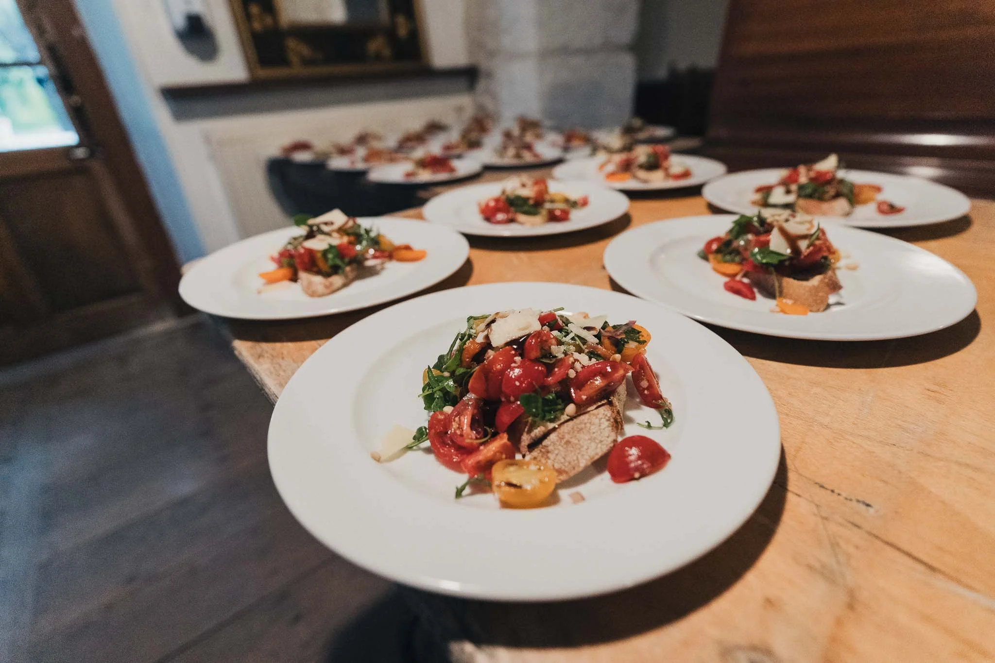 Plated starters arranged on a table ready to be served during the wedding dinner.
