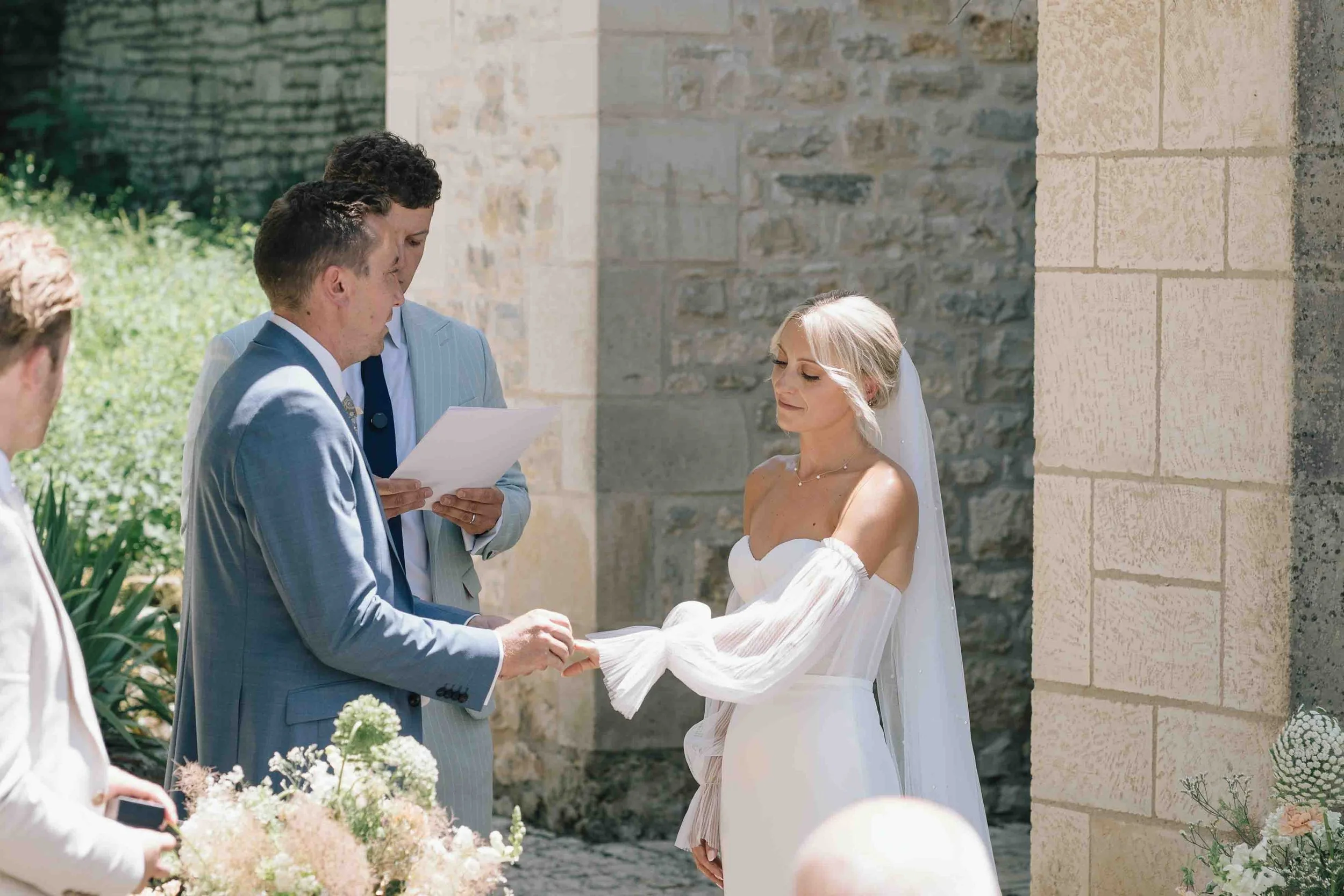 Groom placing ring on bride’s finger during emotional outdoor ceremony in southwest France