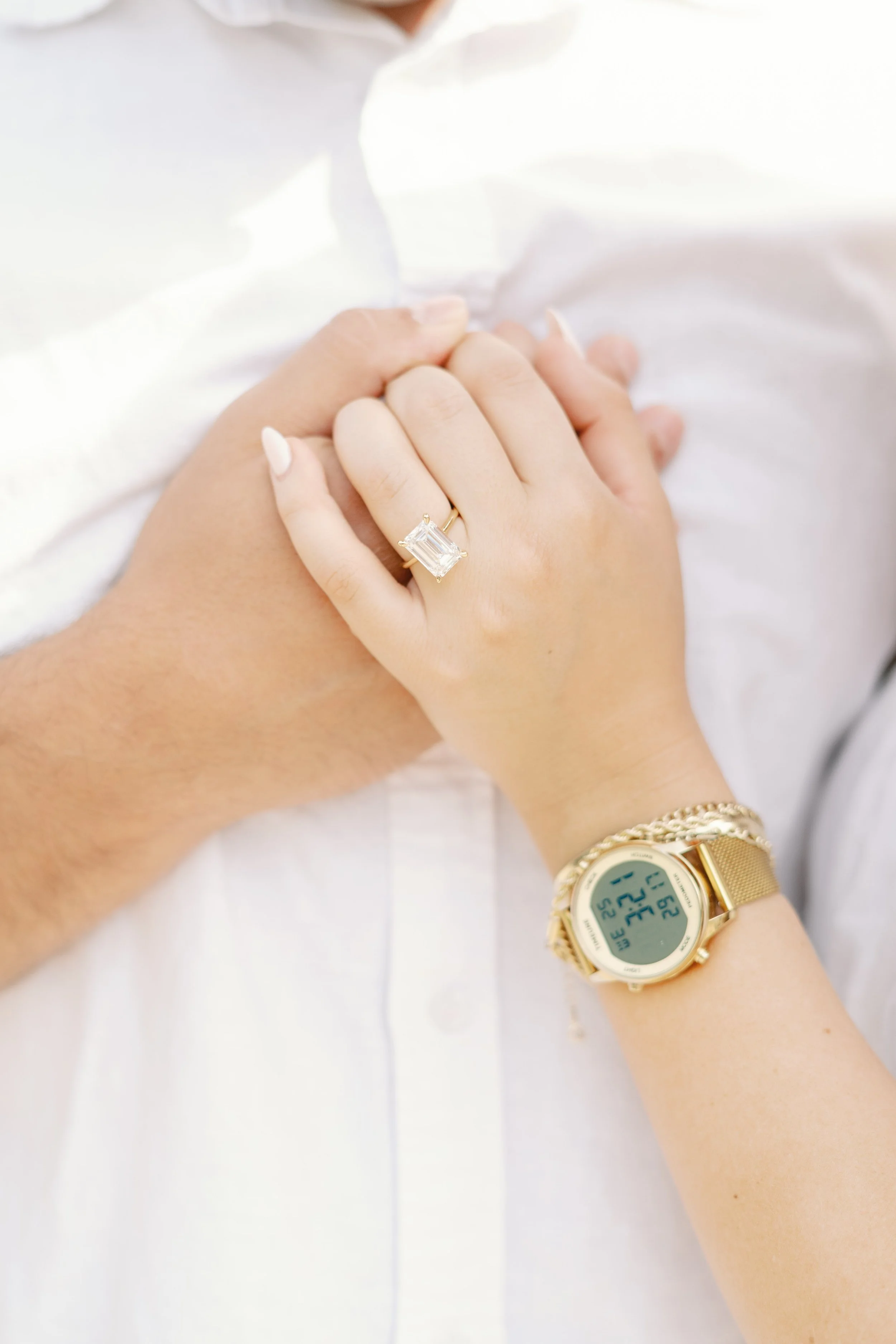 Close-up of engagement ring on newly engaged couple’s hands during a proposal photoshoot in Bordeaux.