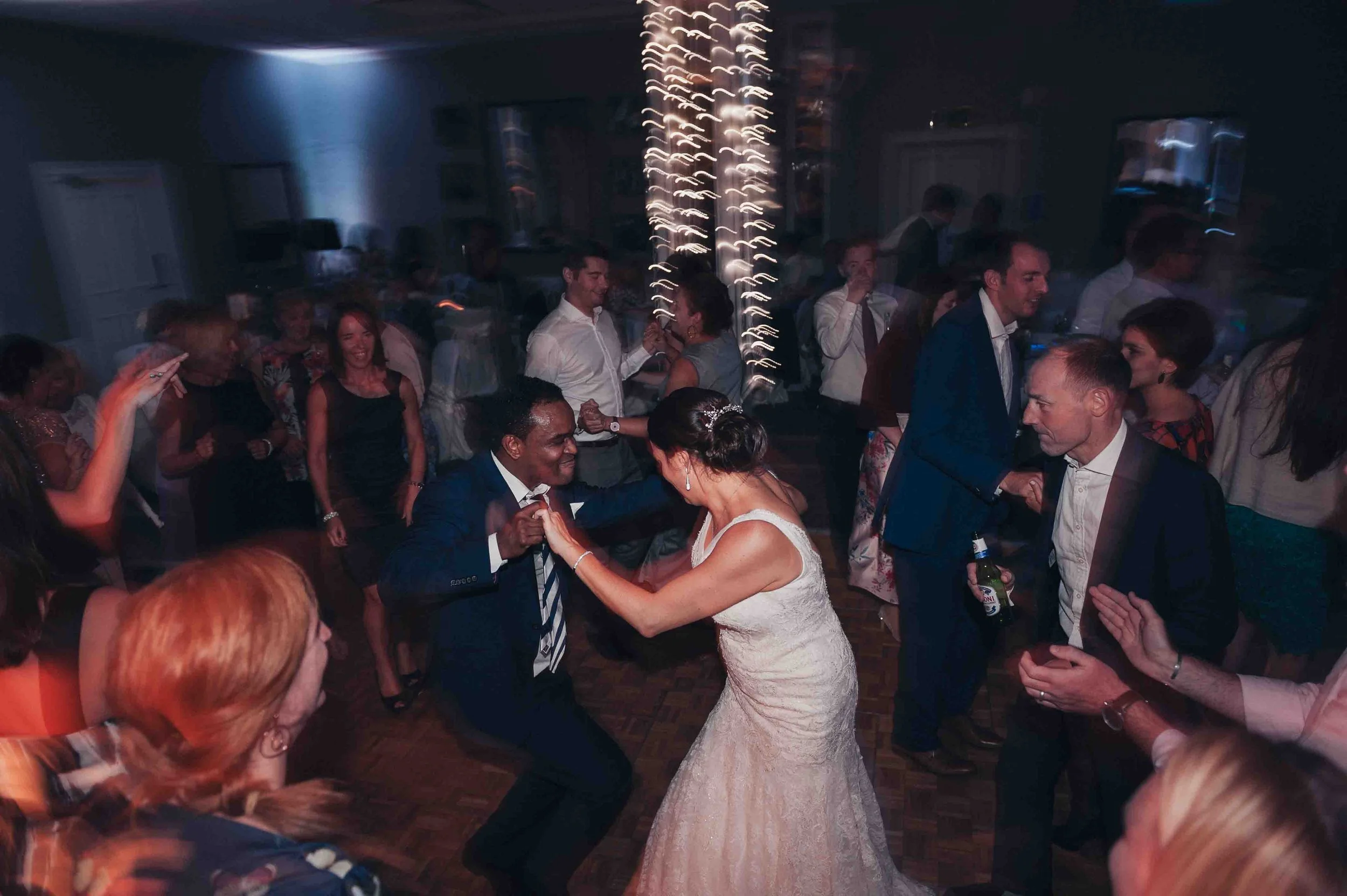 Guests dancing together in the evening as the wedding celebration continues, captured naturally without interruption.