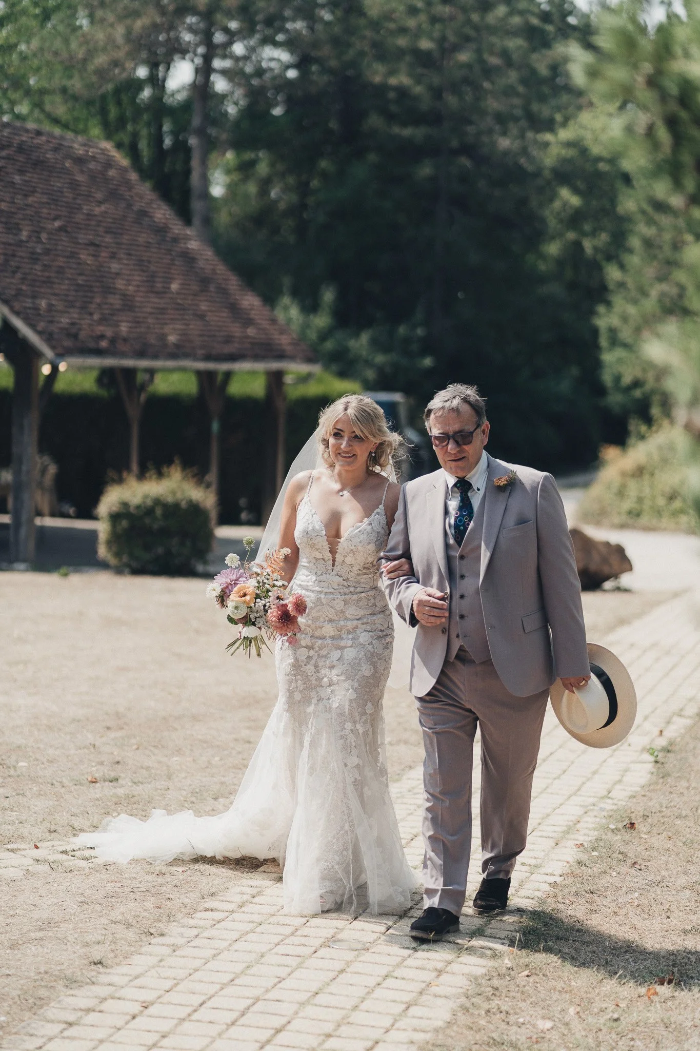 Bride walking arm in arm with her father as they approach the ceremony area.